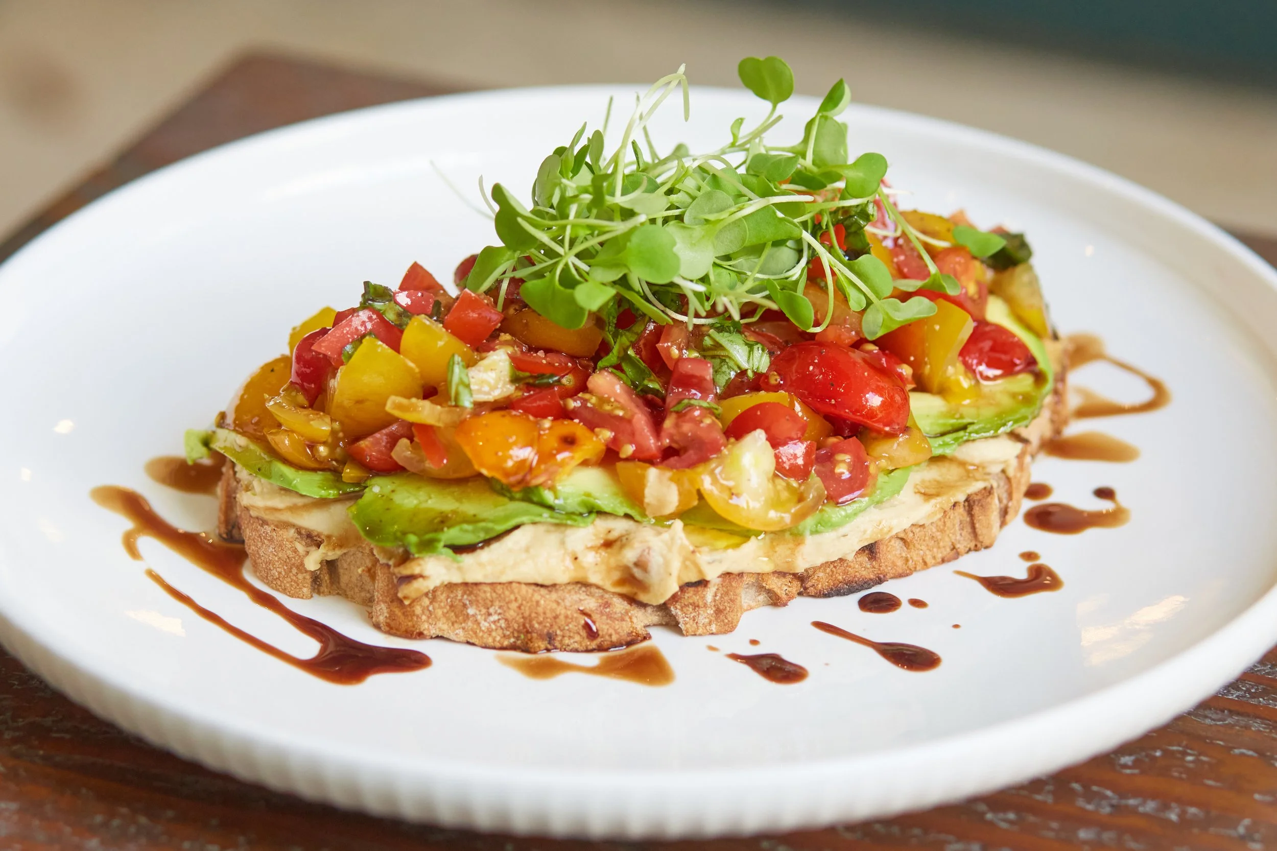 Hummus Avocado Toast (Chickpea 
 Pinenut Hummus, Avocado, Cherry Tomatoes, Fresh Basil, Micro Arugula/Greens, Balsamic Glaze, Olive Oil,
Kosher Salt, Ground Pepper, Your choice of Sourdough, Wheat or Cranberry Walnut Slice)
Link