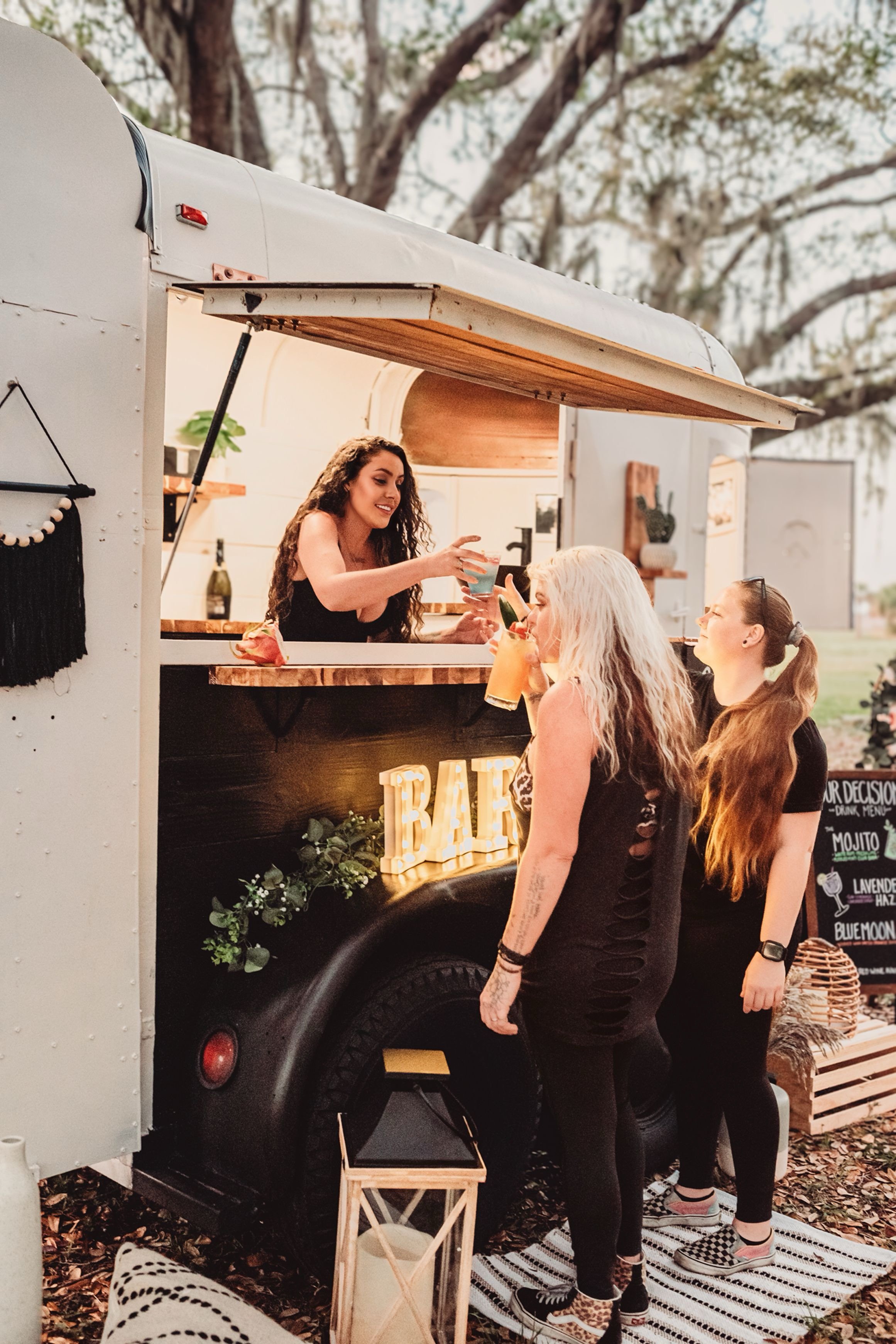 Outdoor mobile bar setup serving drinks to patrons.