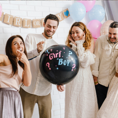Group of people at a gender reveal party with a black balloon labeled "Girl or Boy?"