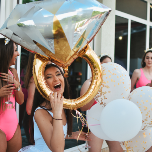 Woman celebrating with ring-shaped balloon at pool party