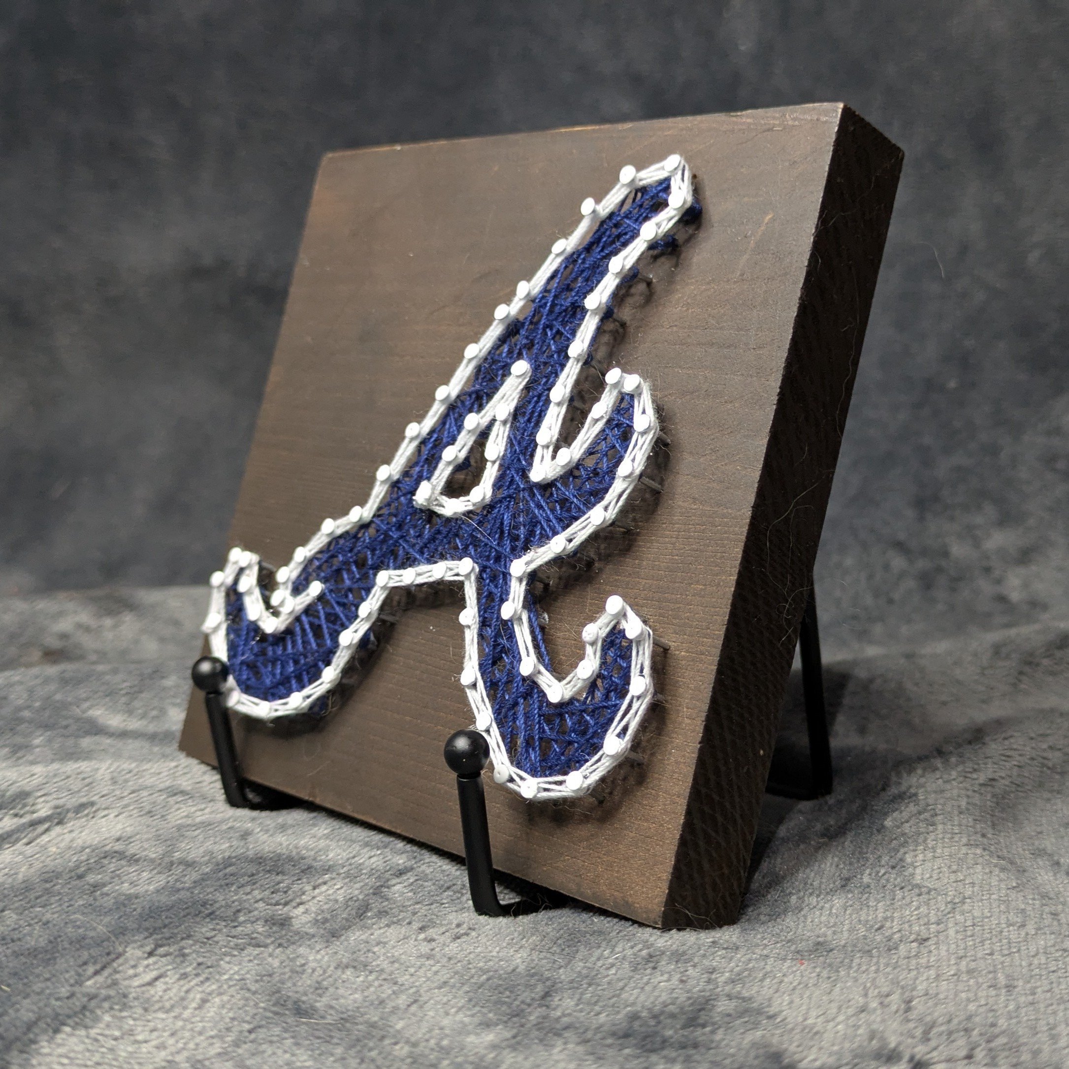 Atlanta Braves Logo Blue with White Border on a Dark Board