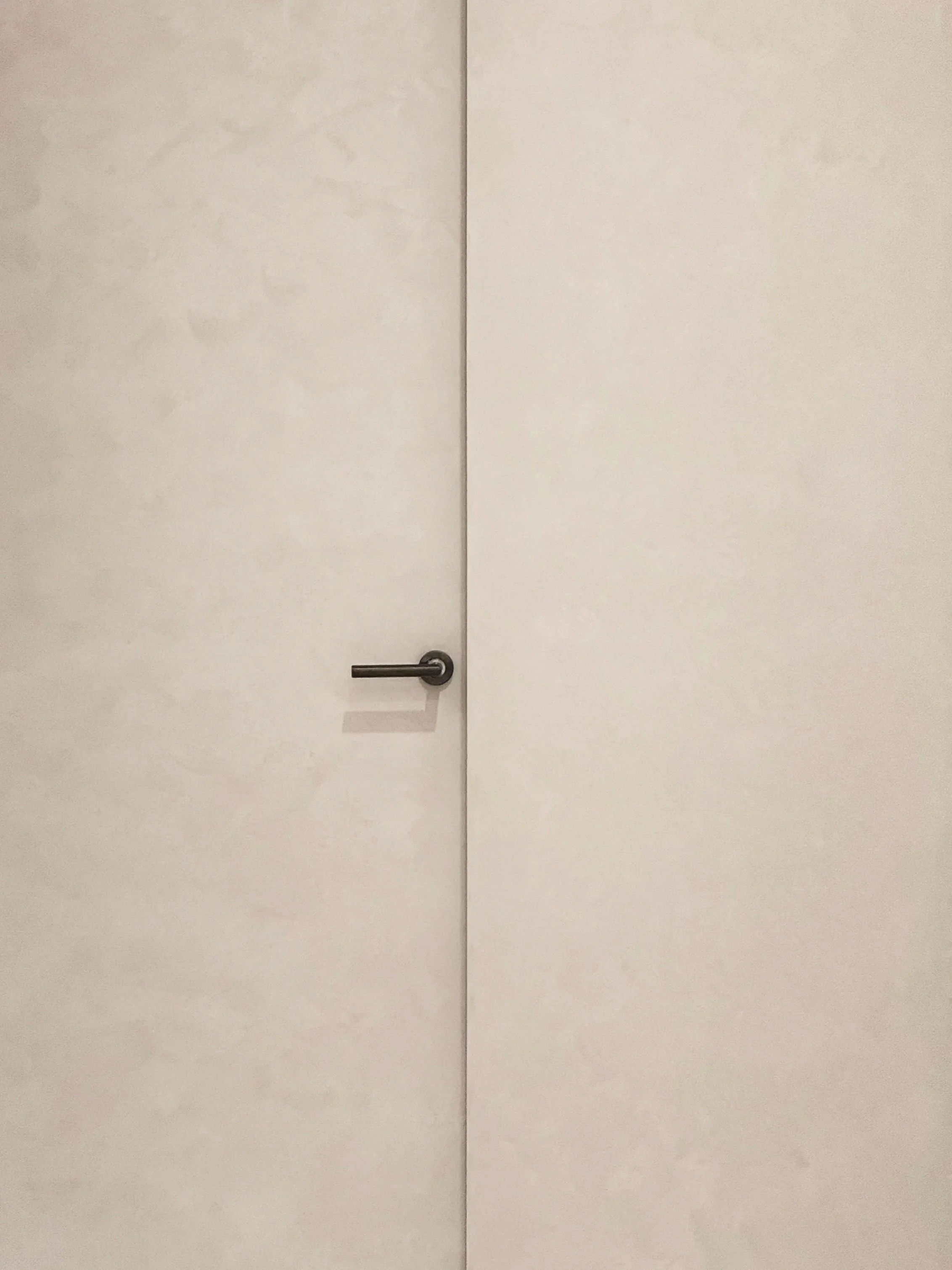 White double doors with a metal handle on the left door in an indoor setting.