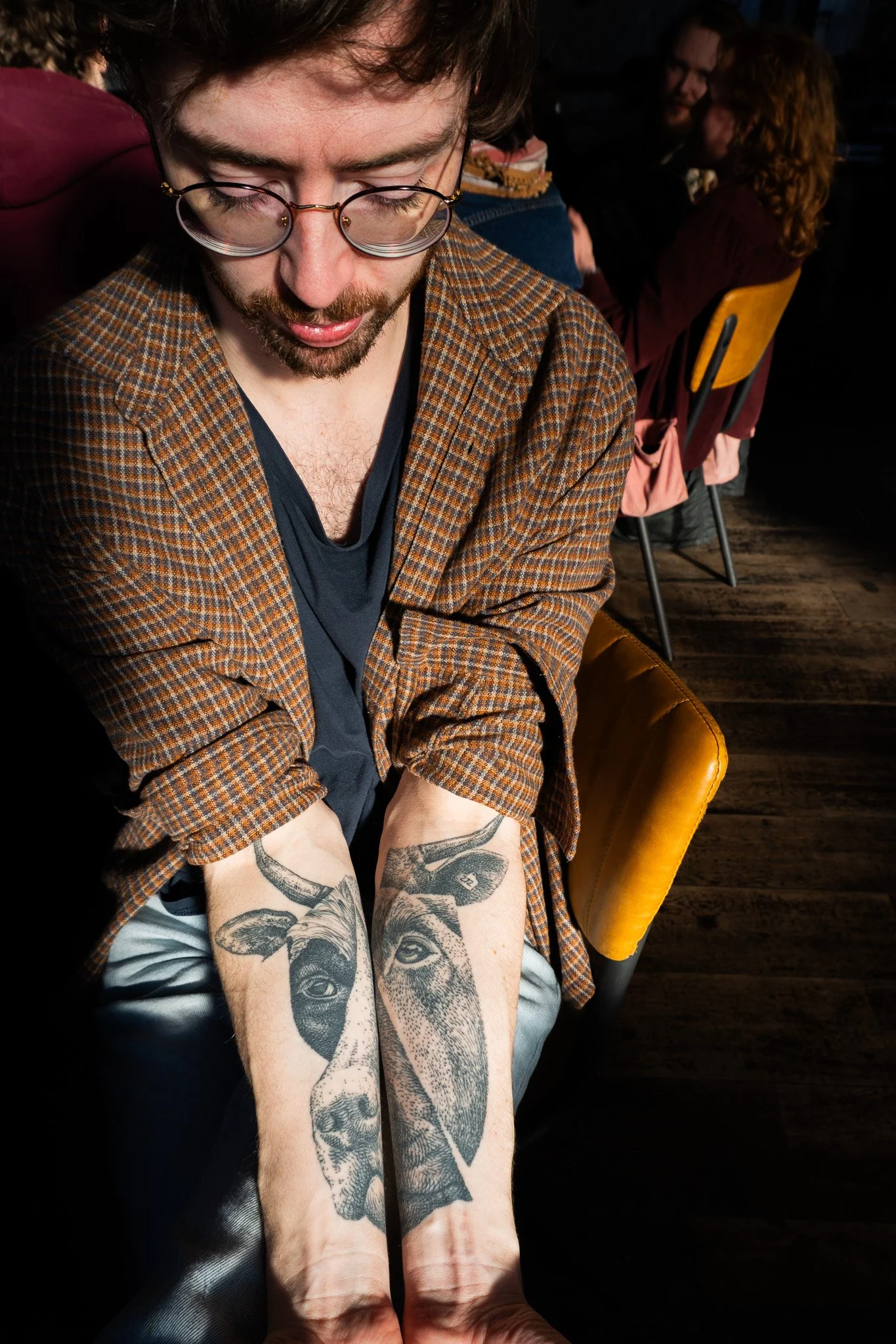 Jack, is pulling his arms together to show his tattoo that depicts a cow and a dog face merged together in one.