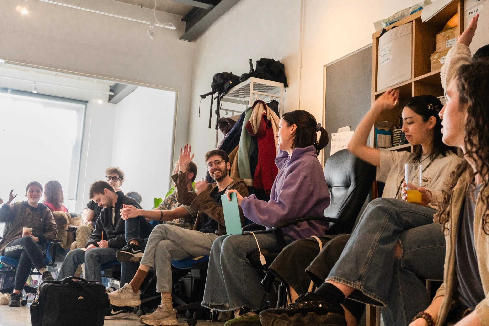 Jack is smiling and raising his hand at a meet-up for plant-based initiatives in London
