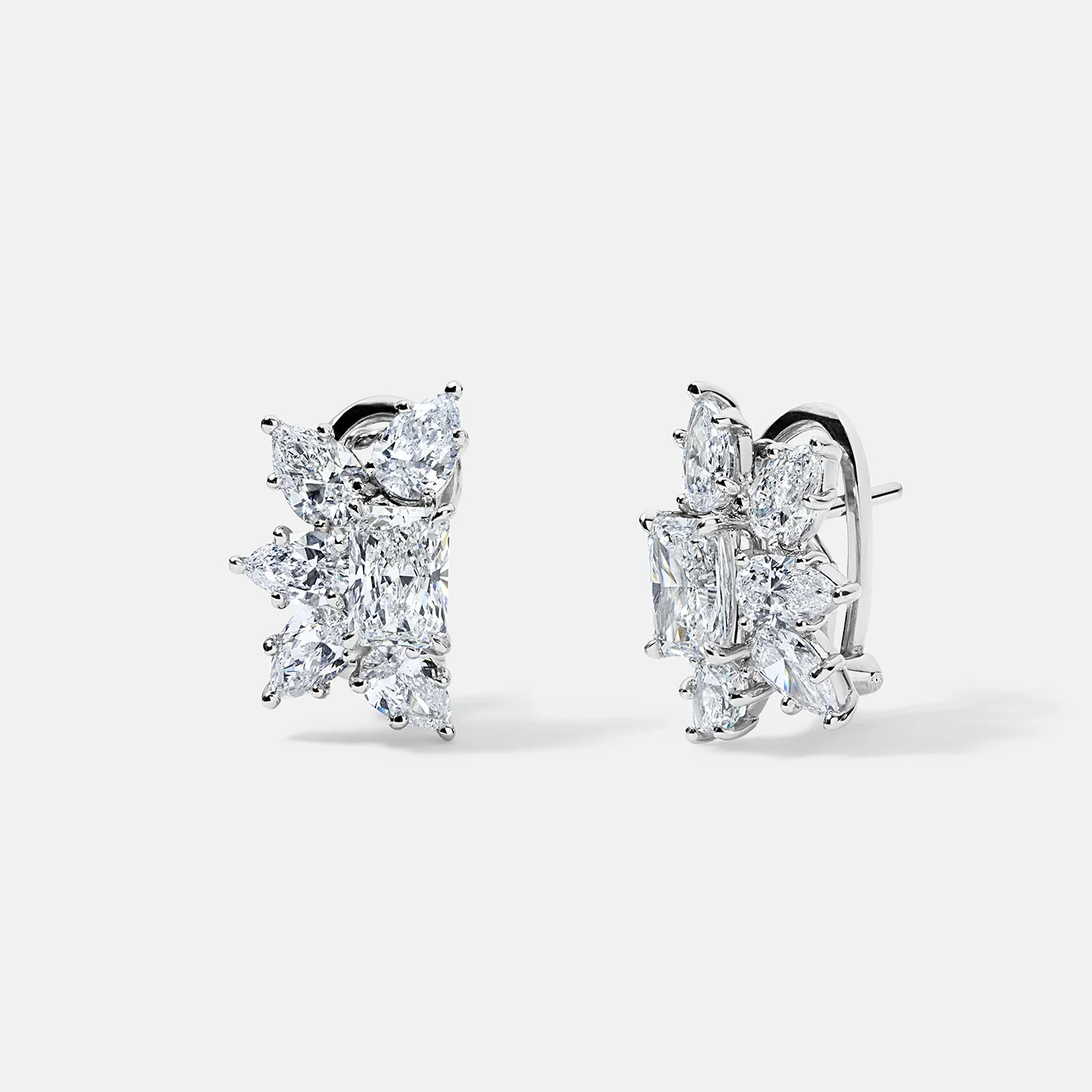 Pair of platinum earrings with a radiant cut diamond center and a wreath of pear shape diamonds.