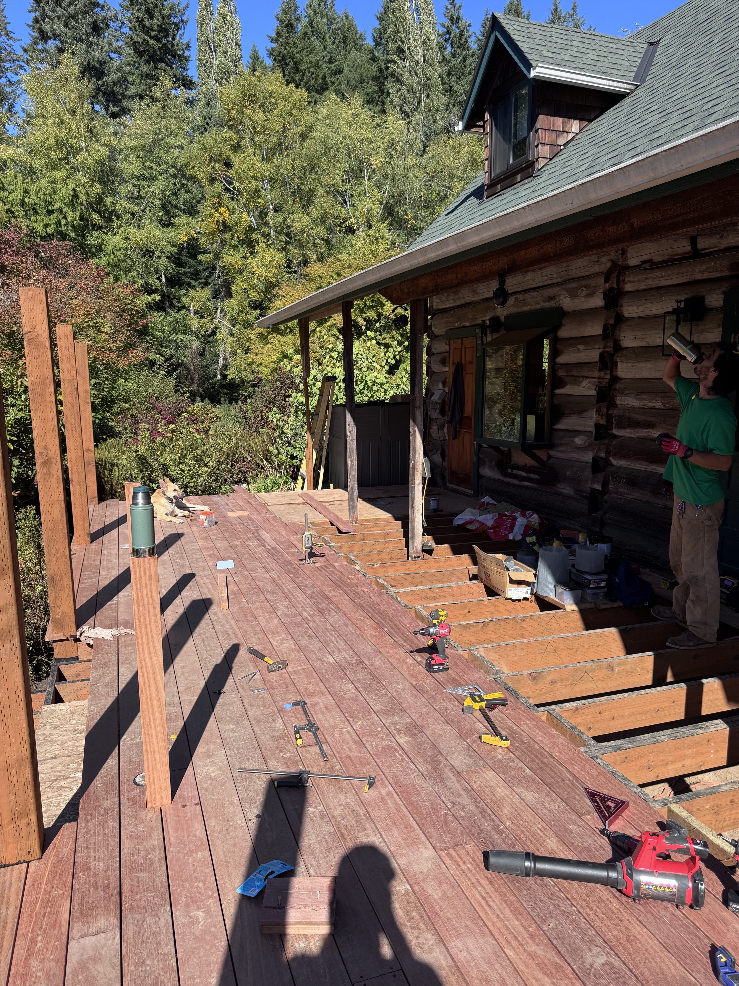a deck under construction on an old log cabin with a forest view
