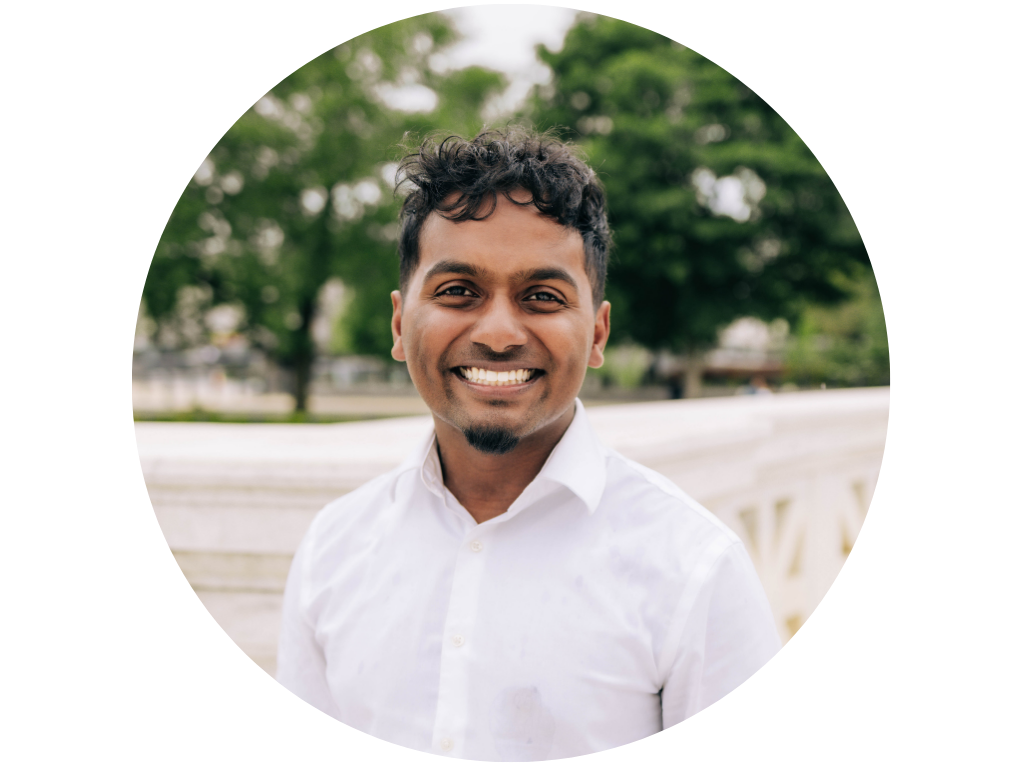 Man smiling in front of trees