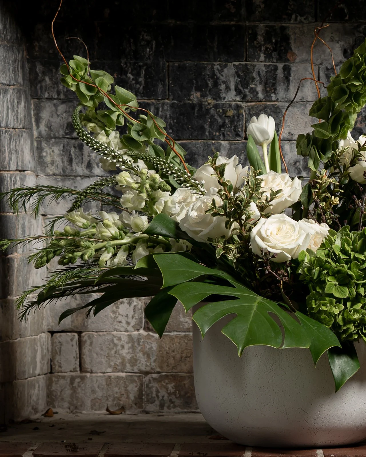 White and green floral arrangement with seasonal blooms in a lush, elegant composition designed with a fresh and refined aesthetic