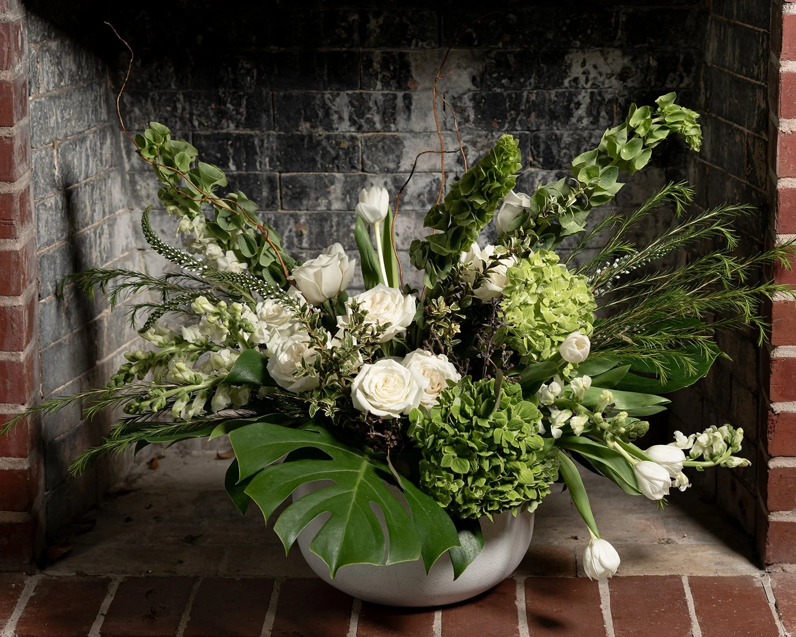White and green floral arrangement with seasonal blooms in a lush, elegant composition designed with a fresh and refined aesthetic