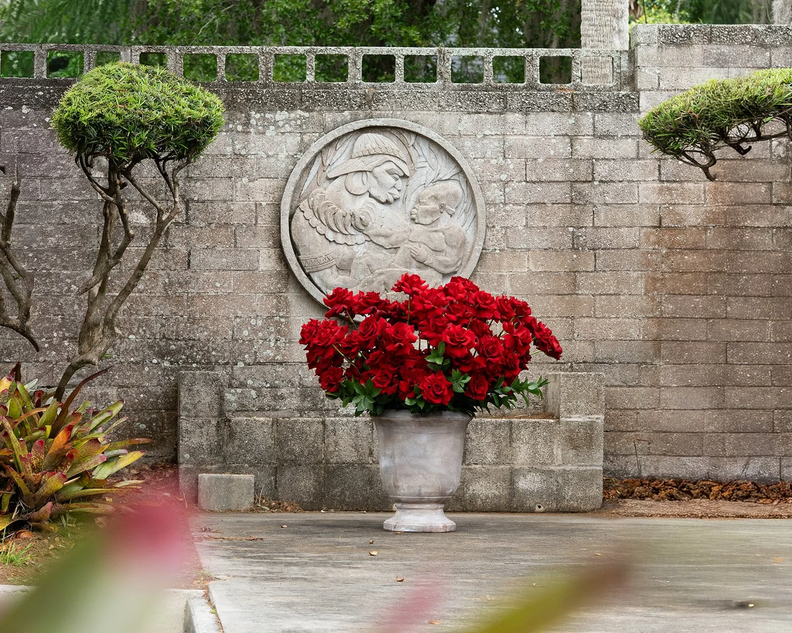 100 reflexed roses arranged in a full, sculptural and romantic floral composition with open blooms