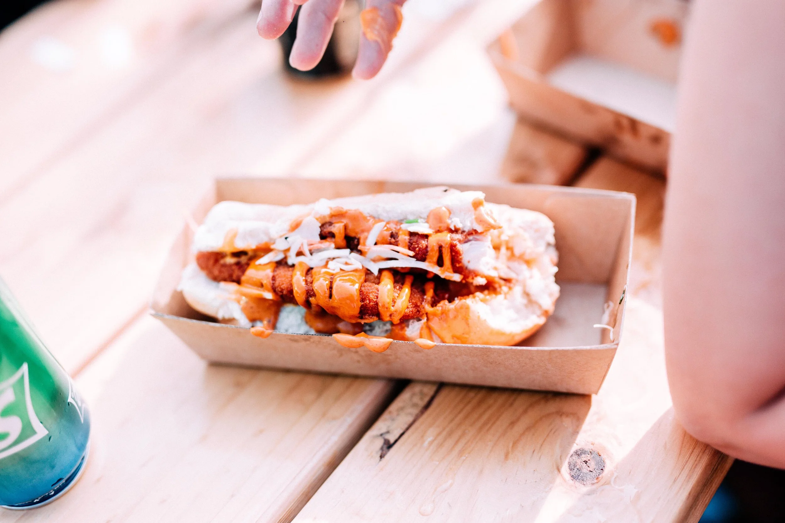 Schnitzel roll in bun in brown take away box.