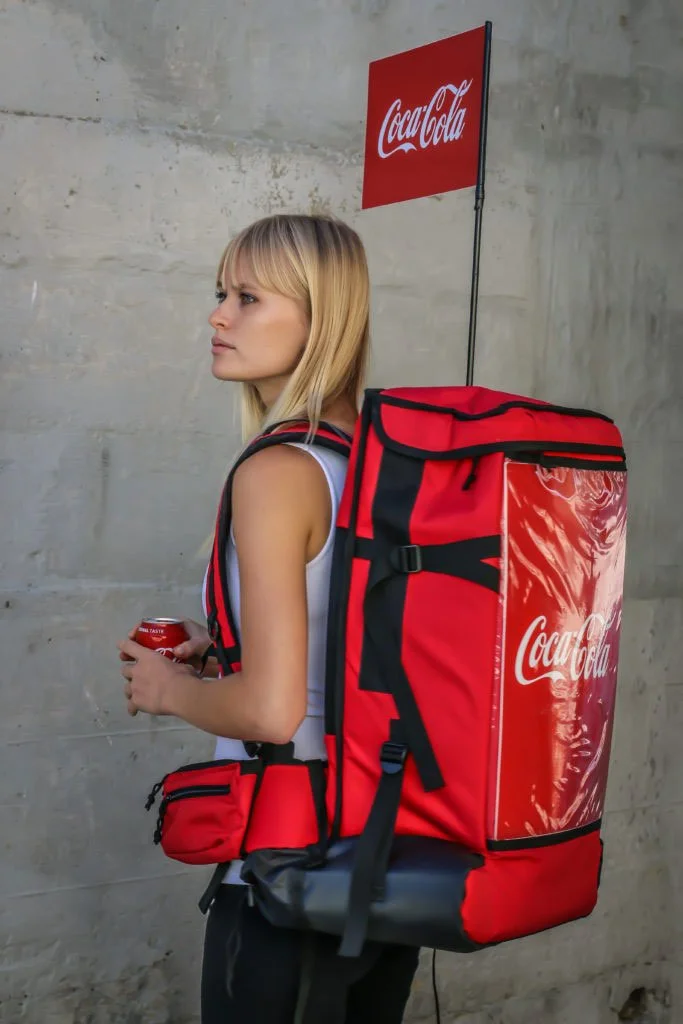 blonde girl wearing a mobile beverage service backpack