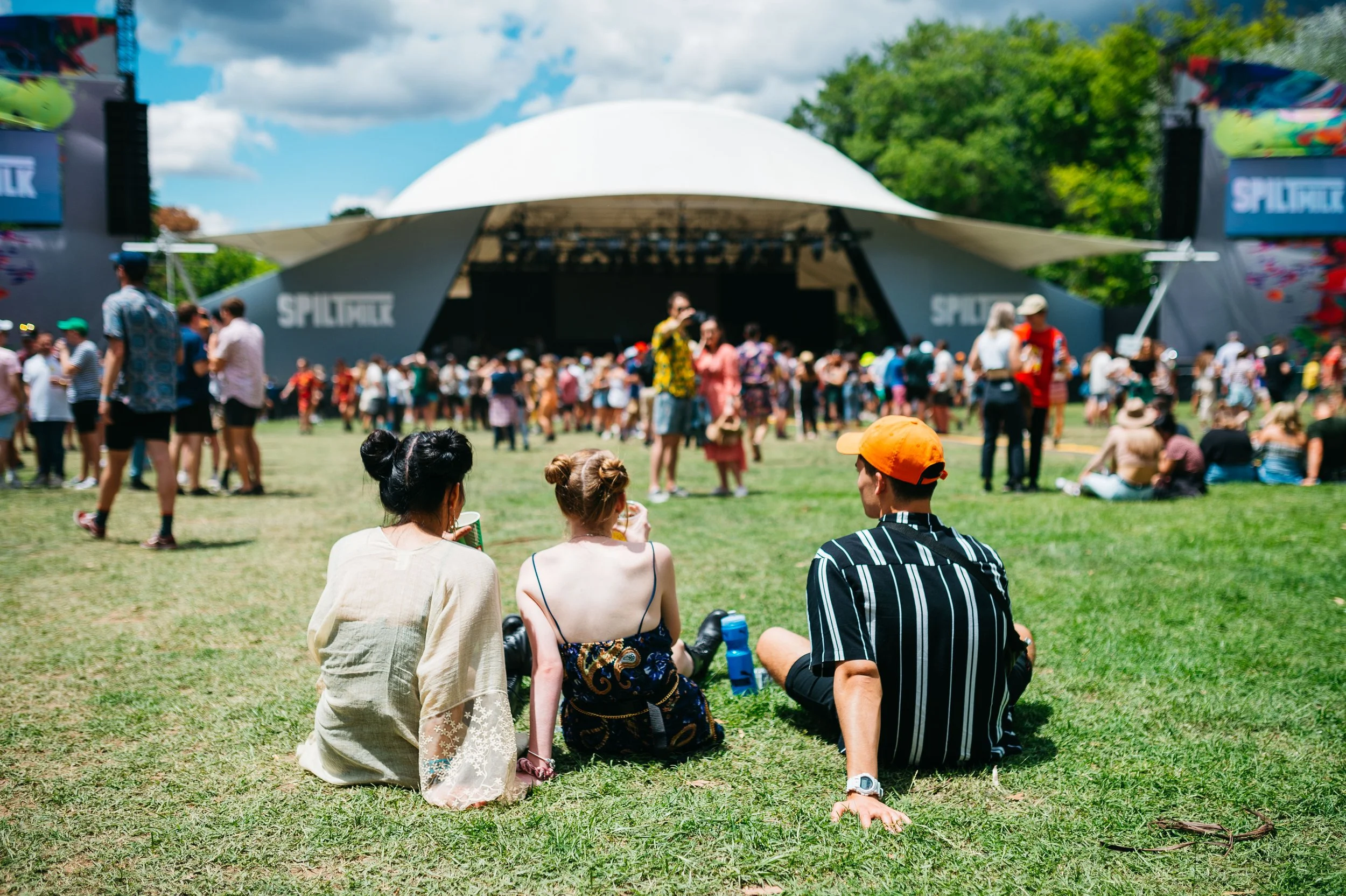Few people sitting in front of Spilt Milk dome stage.