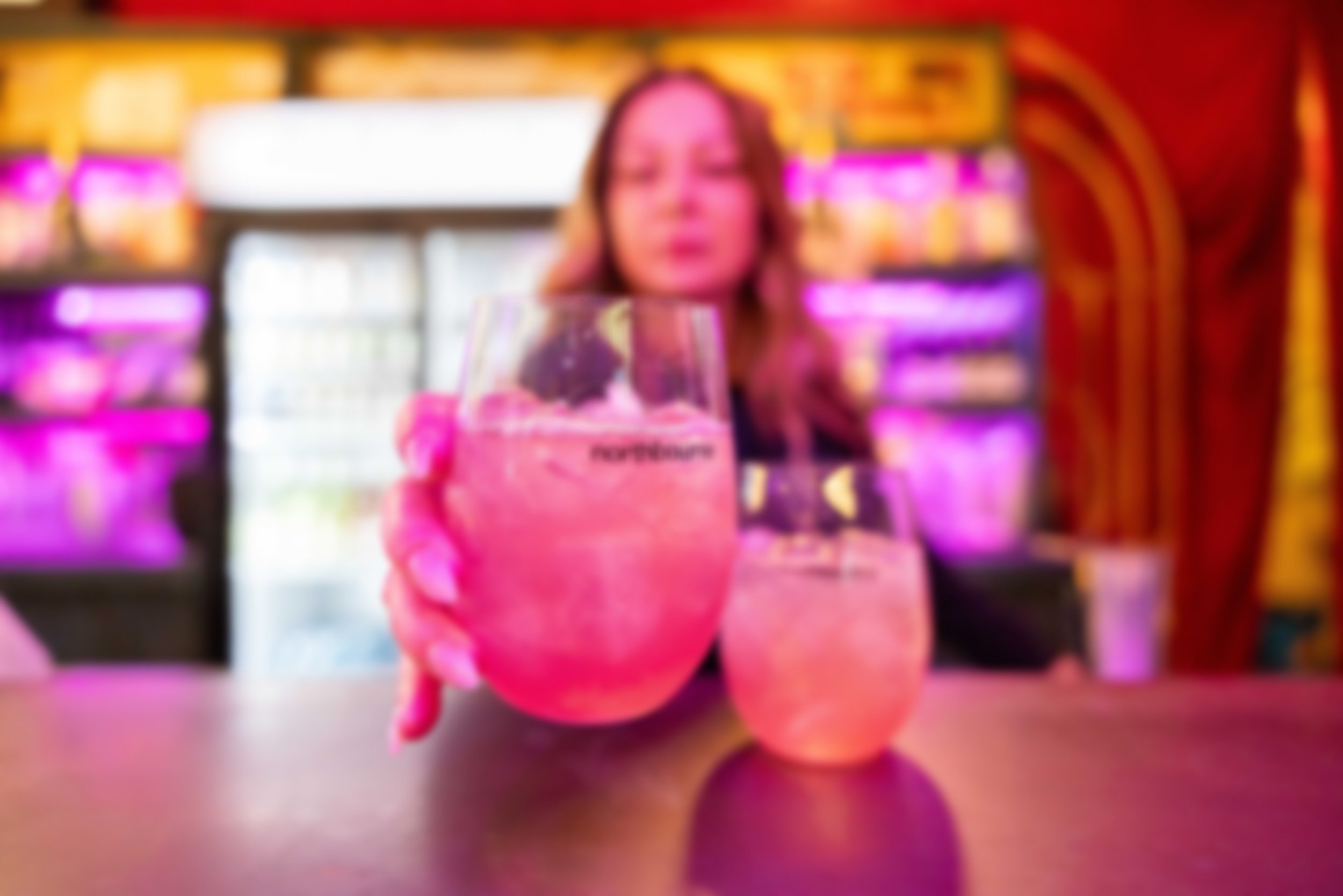 woman at bar setting glasses with Northbourne branding on bar
