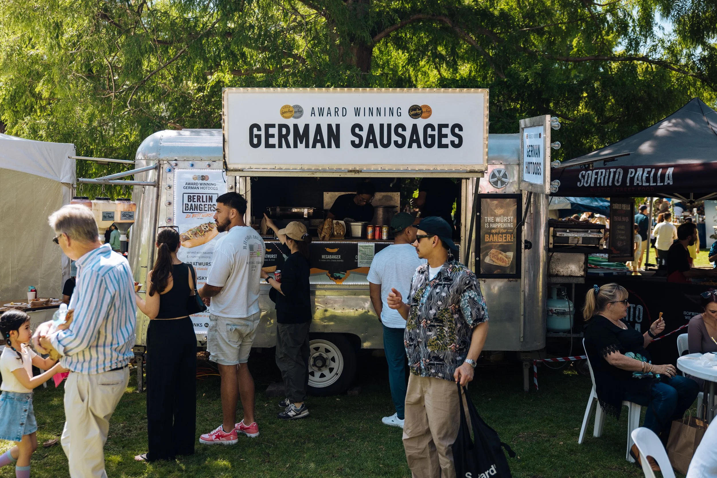 Food truck German Sausages, and people waiting out front.