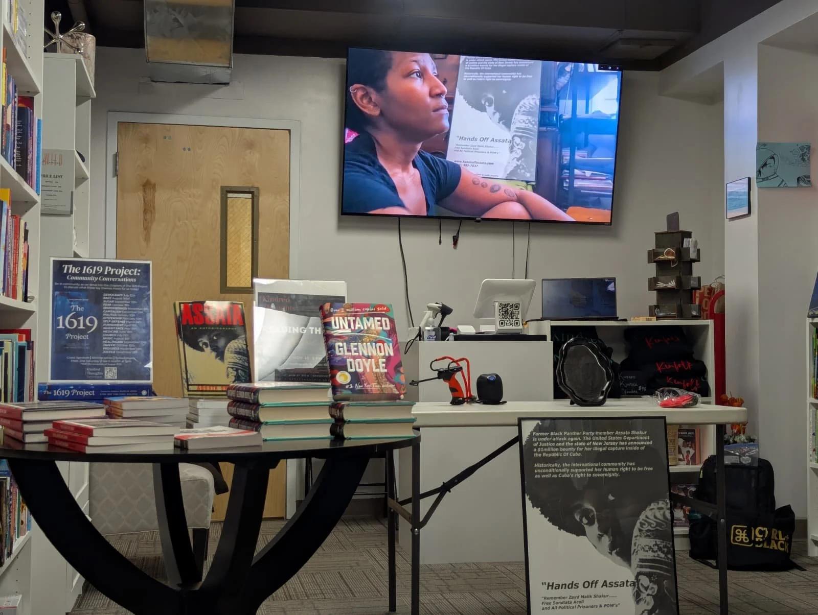 Inside of Kindred Thoughts Bookstore at the Bridgeport, CT screening. Kenyatta is on the screen with Assata's portrait in the background and in the photo