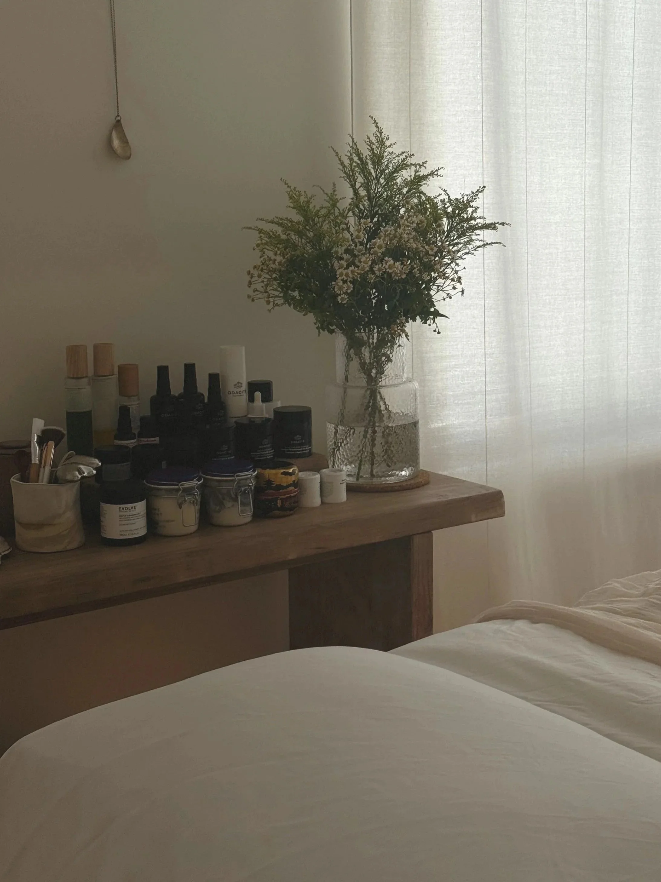 beautiful facial treatment room, white and light wood table, flowers, ira skin rituals facial room