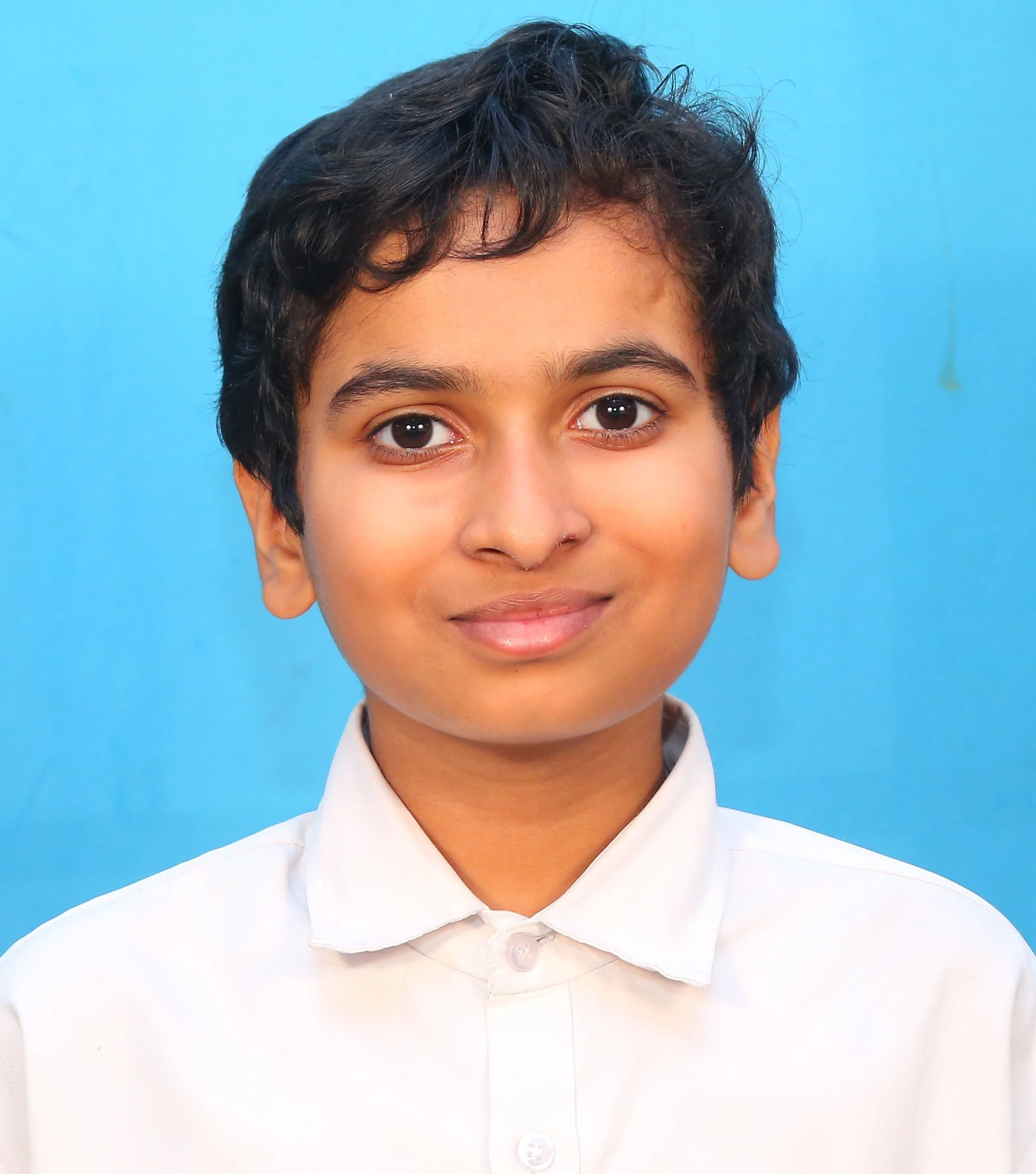 Portrait of a young person in a white shirt against a blue background.