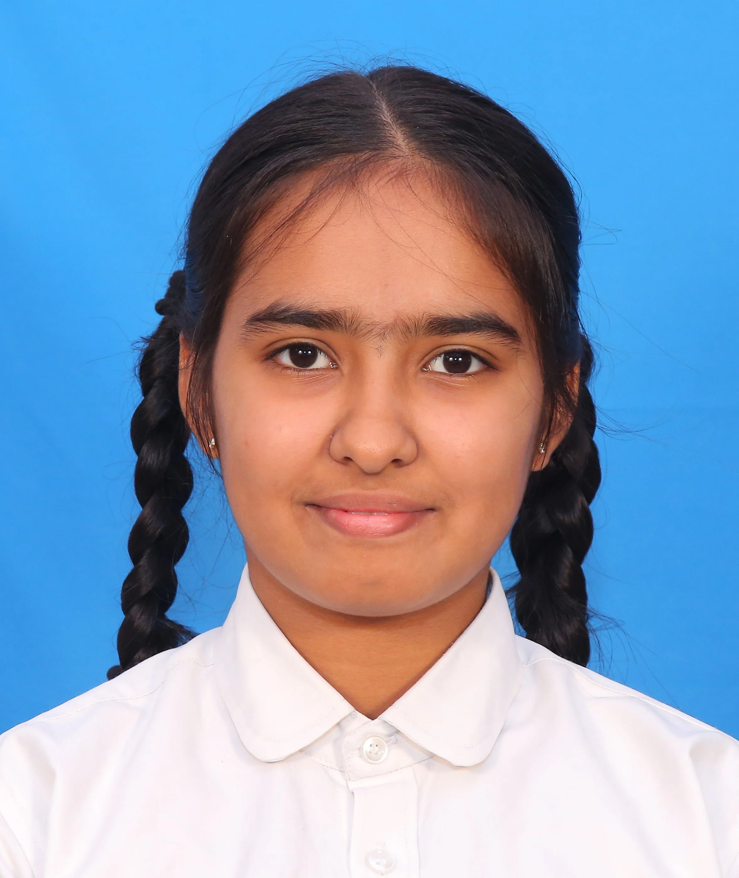 Portrait of a person with braided hair, wearing a white shirt, against a blue background.