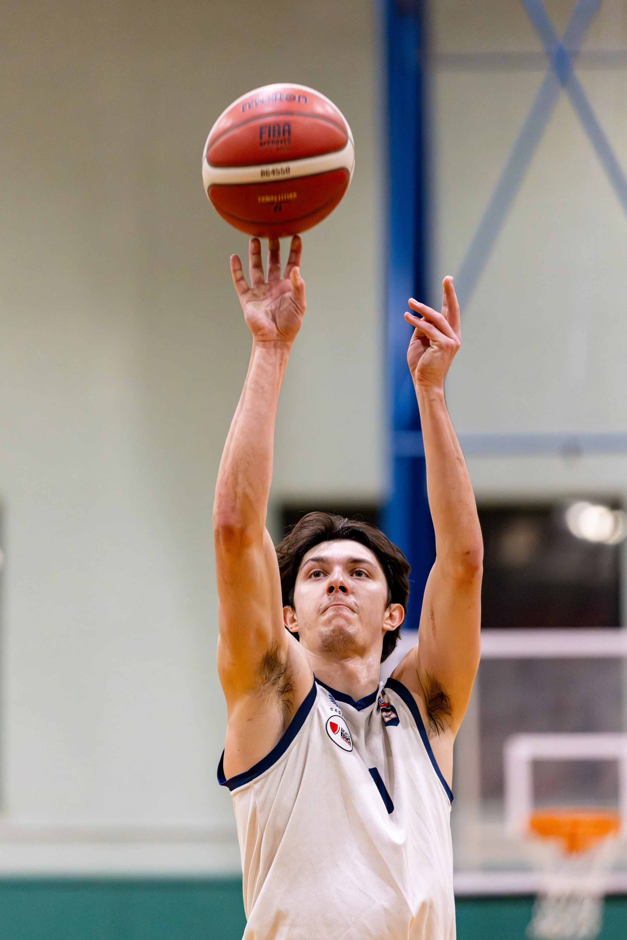 A male basketball player shooting a basketball during a game.