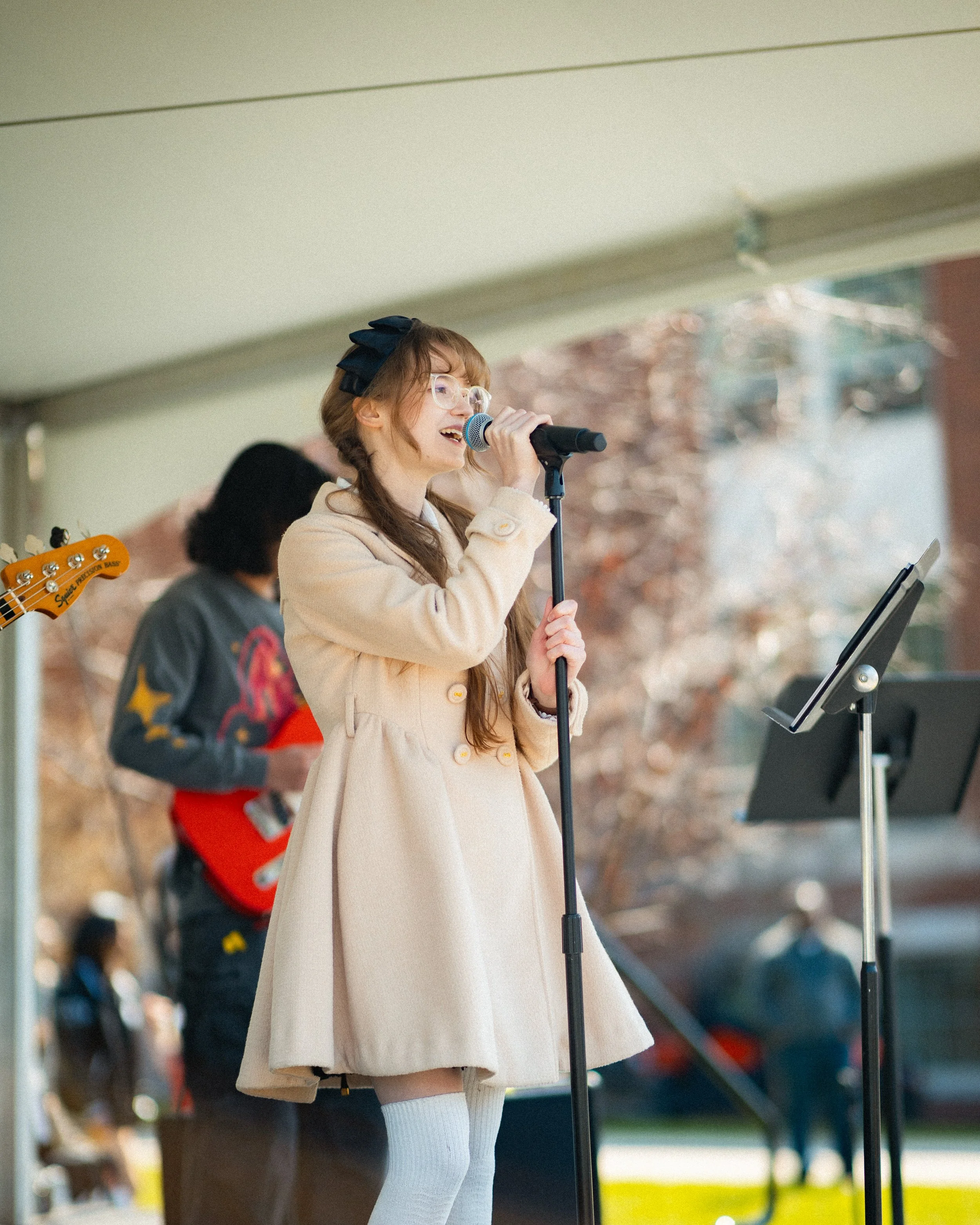 Young girl singing into a microphone during an outdoor performance