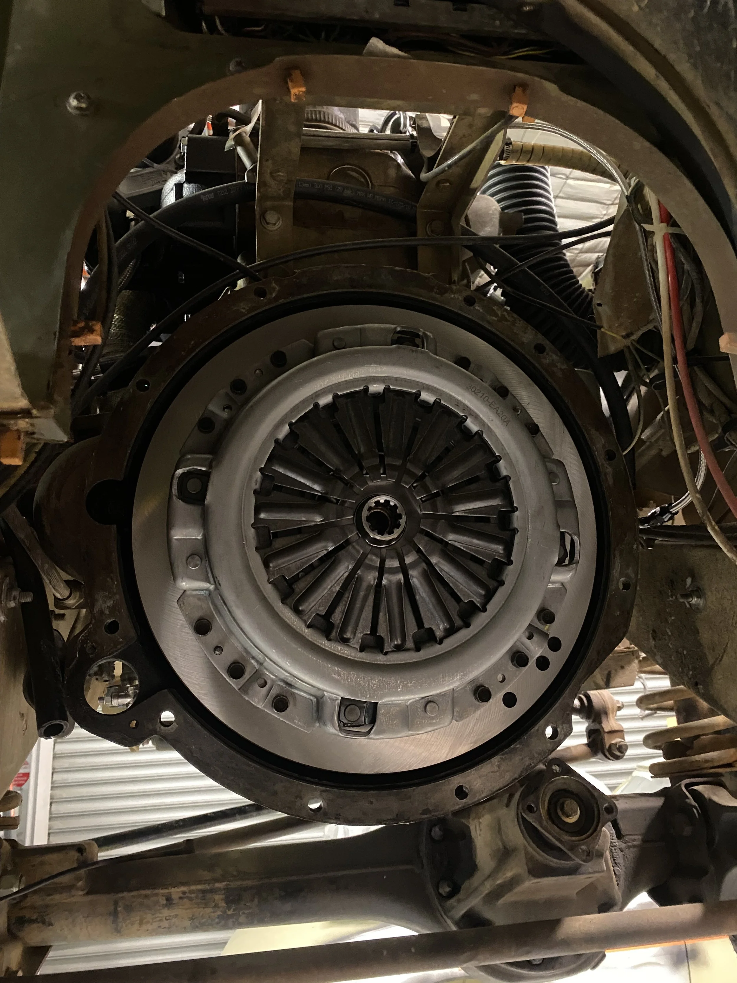 Close-up of a disassembled automotive engine with visible clutch assembly and surrounding mechanical parts.