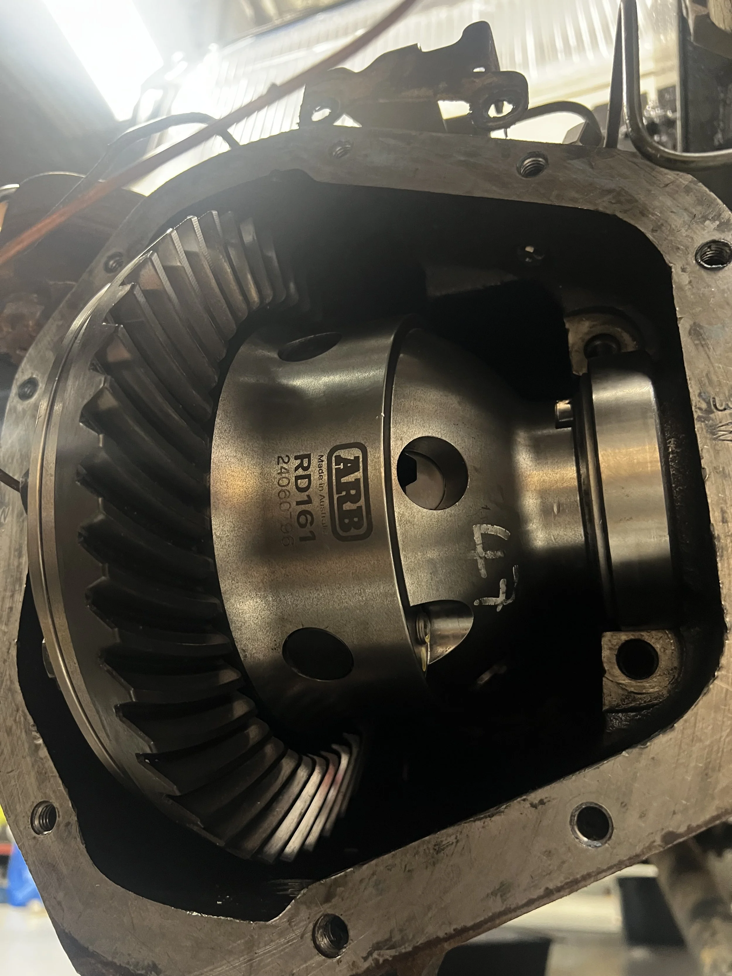 Close-up of a mechanical component, likely part of a machine or engine, with metal housing and internal gear or rotor, marked with the label TRT3 RD1969.