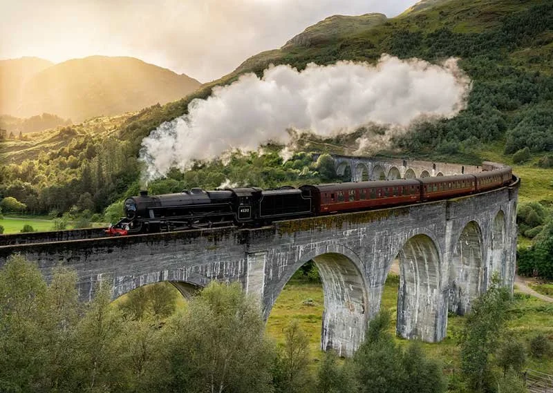 Glenfinnan Viaduct with traditional hogwarts express steam train