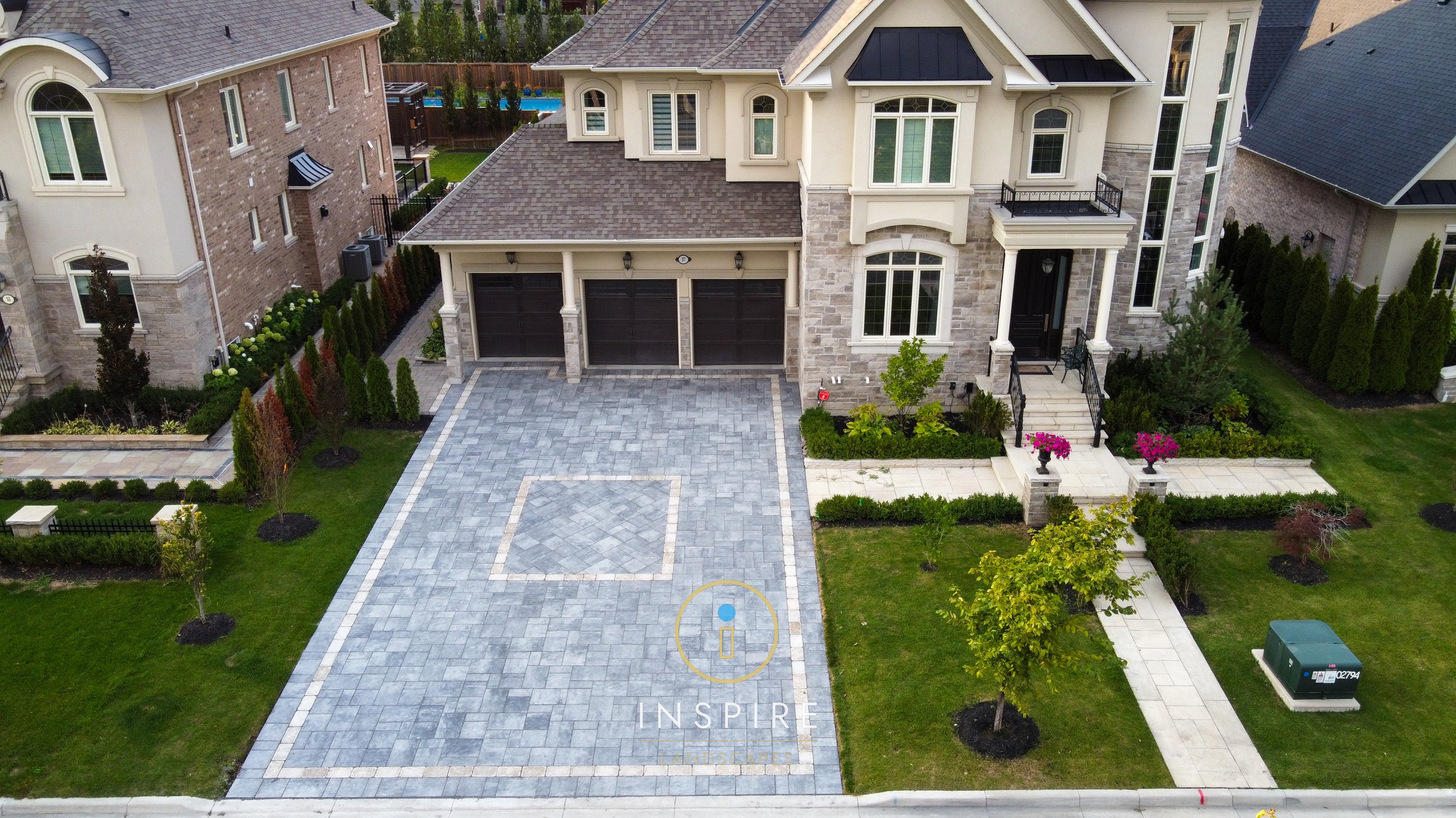 Luxurious mansion in Vaughan with asphalt driveway replaced with Unilock Beacon Hill pavers installed in a random combo with Unilock Brussels Block accents