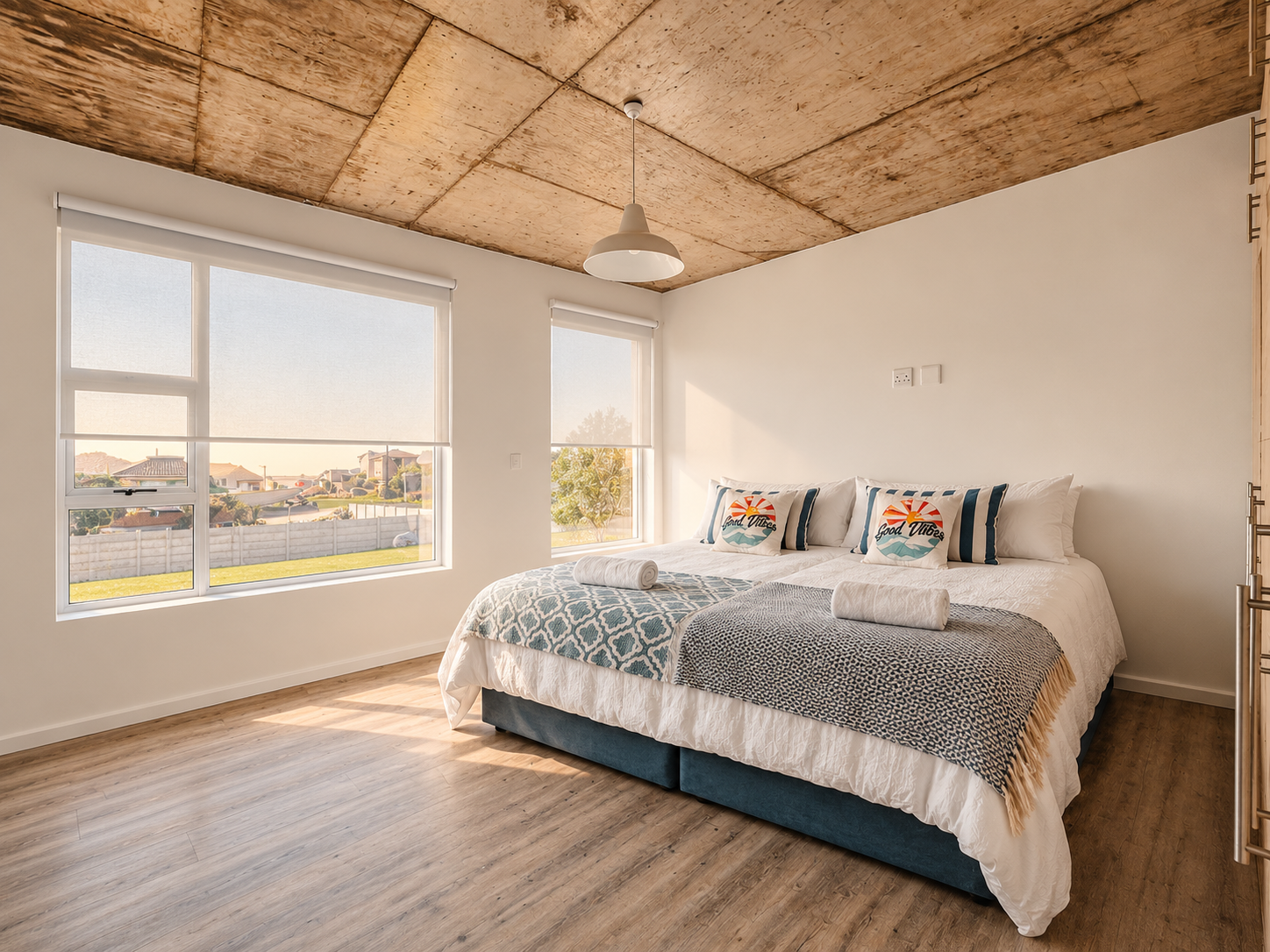 Bedroom with broad windows overlooking the coastal neighbourhood