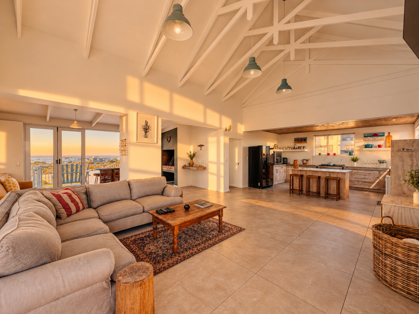 Open-plan lounge and kitchen beneath a white vaulted ceiling