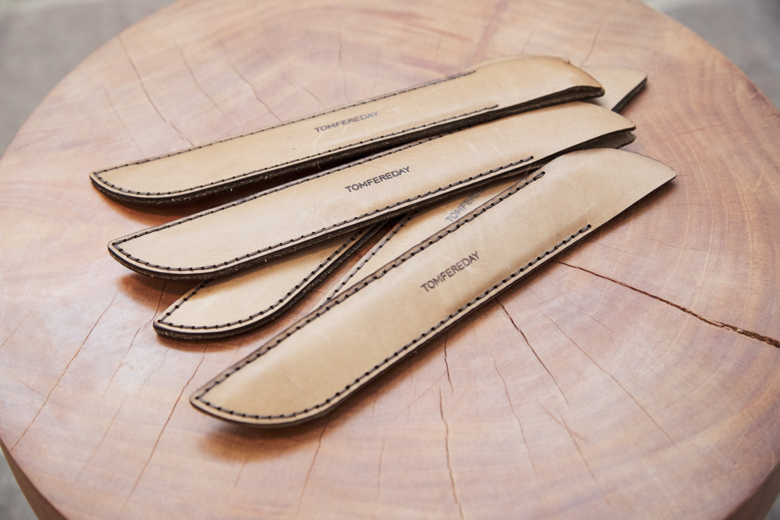 Leather knife pouches on wooden surface