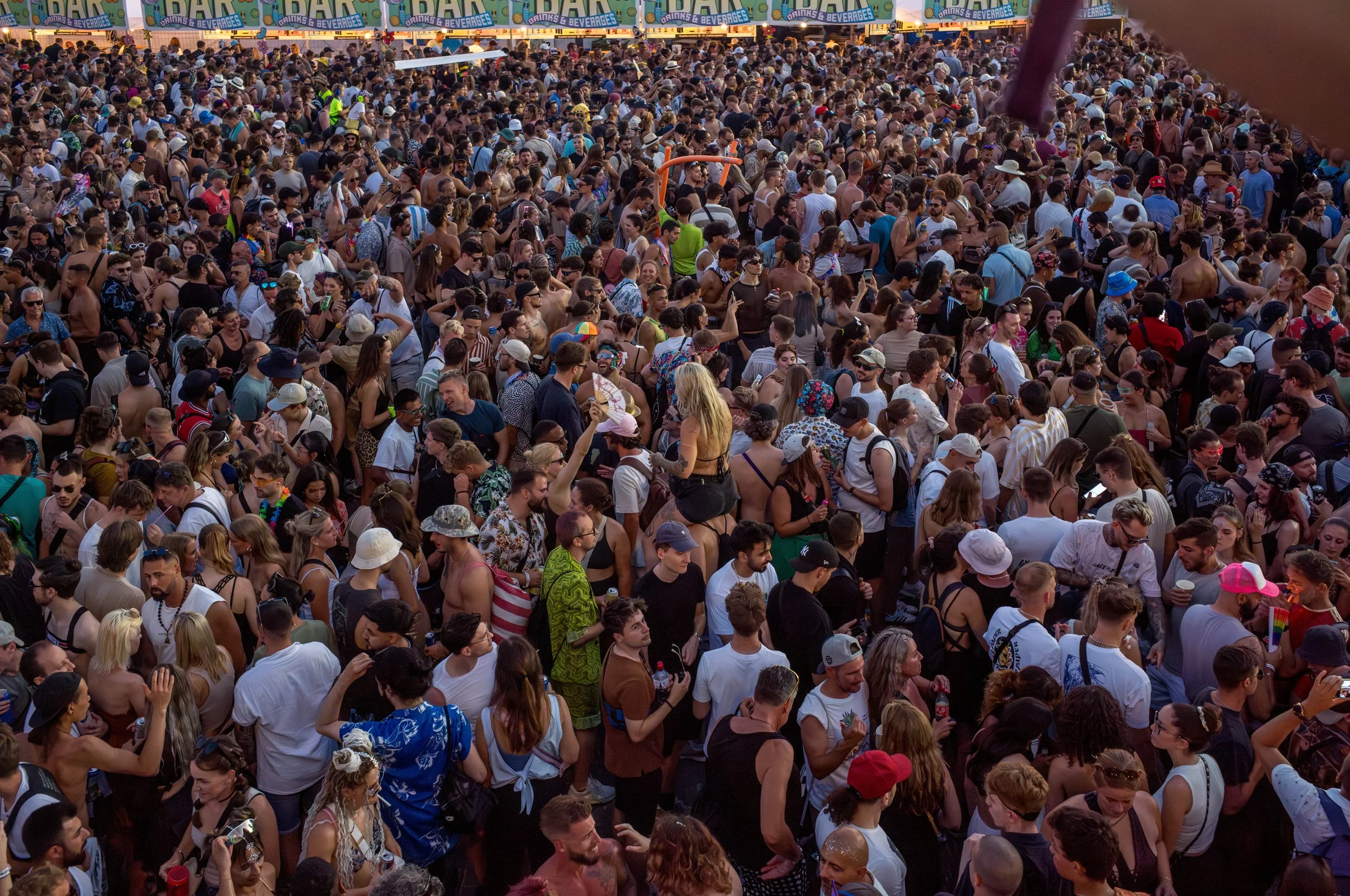 Menschenmenge bei einem Festival oder Event mit Zelten im Hintergrund.