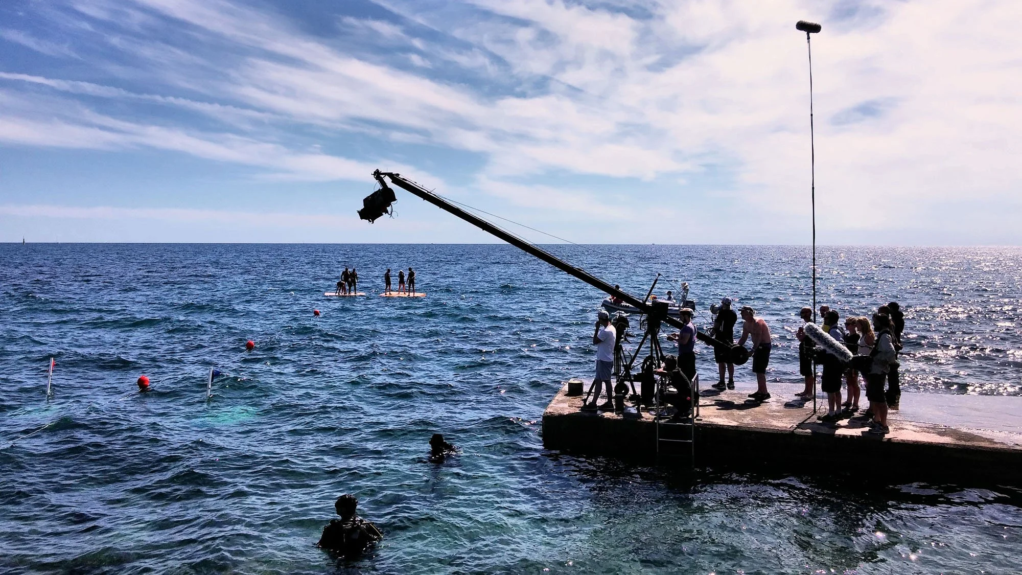 ViEdo camera crew operating a film crane on the coast filming swimmers in the sea in Croatia