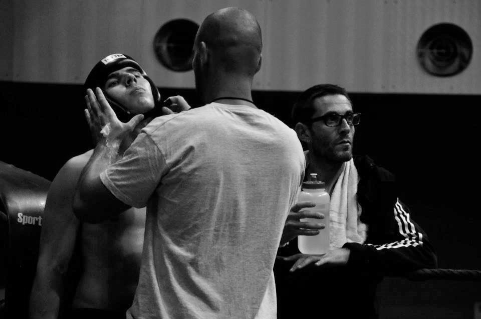 Coach ajuste le casque au combattant qui est dans son coin