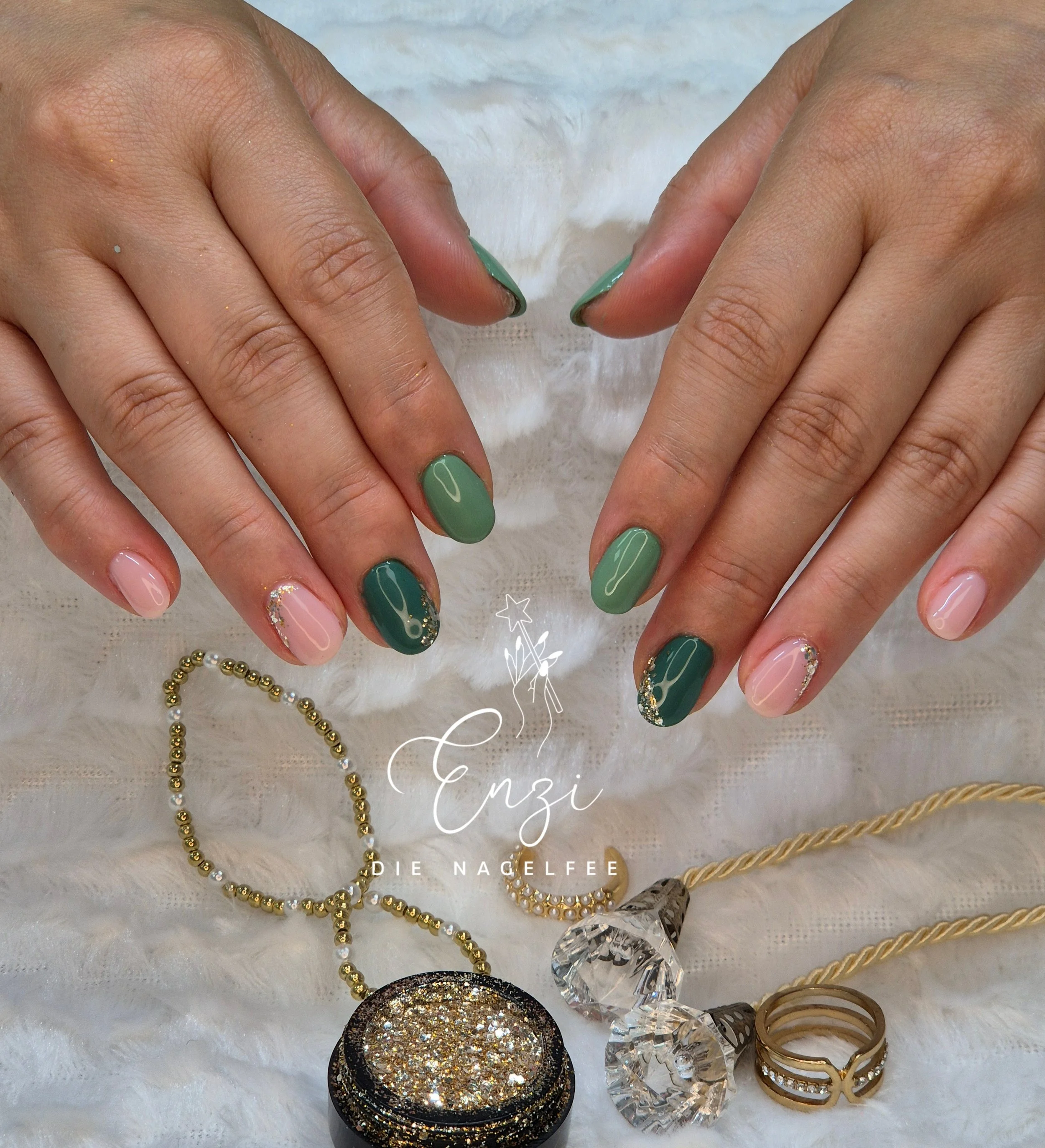 Nahaufnahme von gepflegten Fingernägeln mit grünem und pinkem Nagellack, zusätzlich Schmuck wie Ring, Kette und Ohrringe, auf weißem Stoff