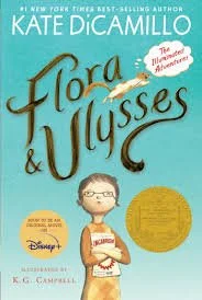 Book cover of 'Flora & Ulysses' by Kate DiCamillo featuring a girl with glasses holding a book, with a blue background and gold circle, Disney logo, and author's name.
