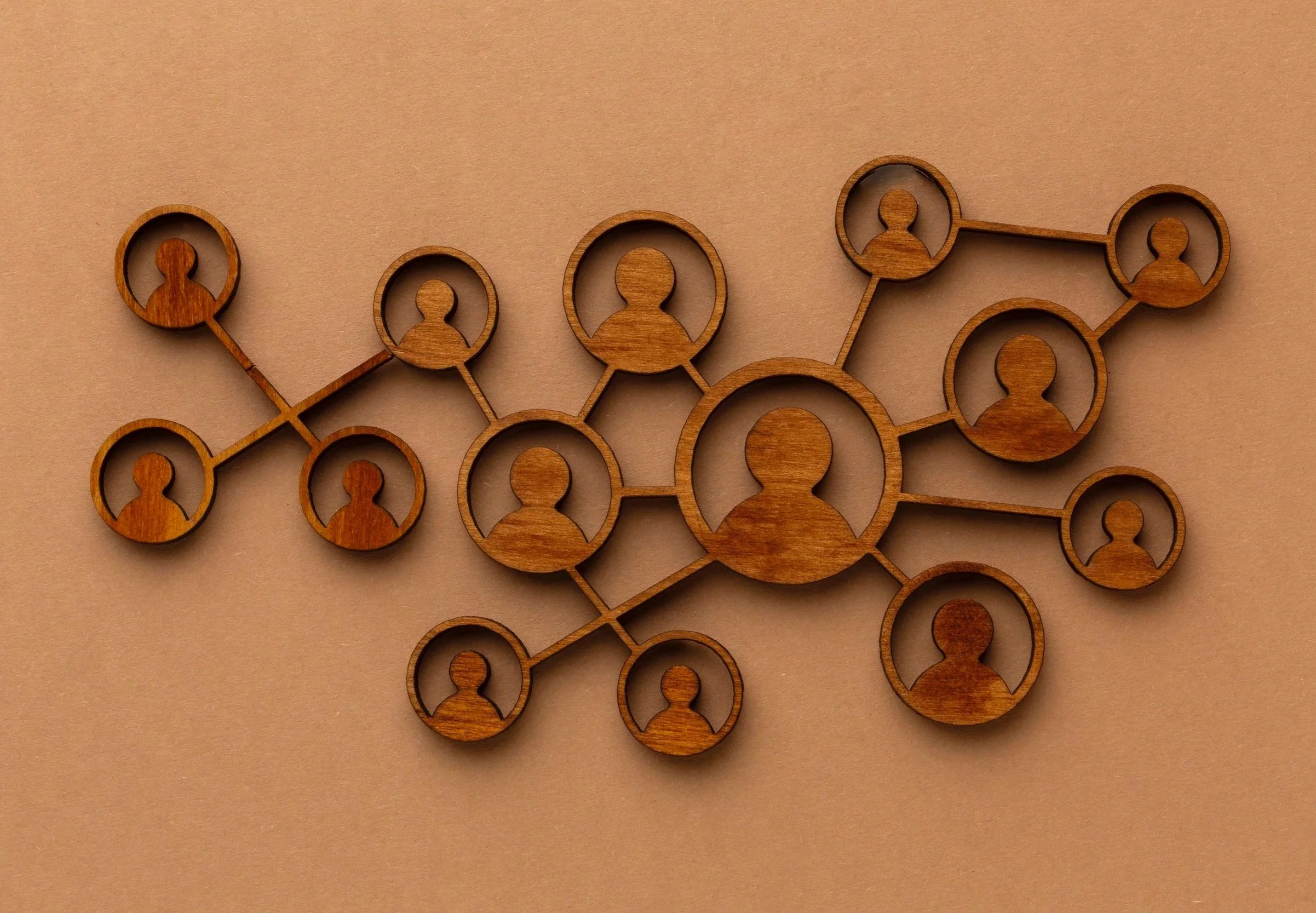 Wooden network diagram with interconnected circular icons representing people.