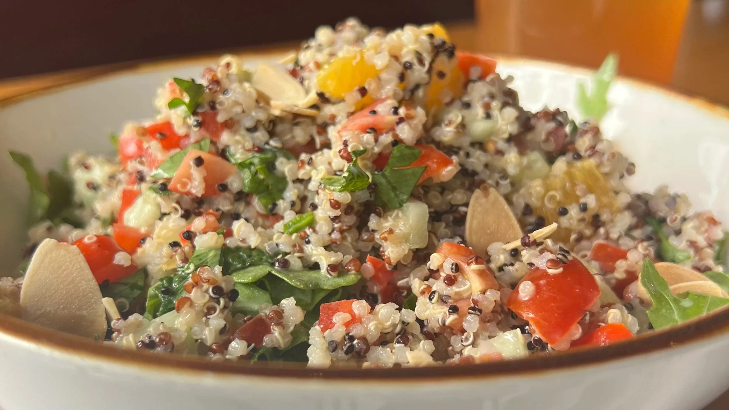 quinoa arugula salad with tomato, bell pepper, cucumber, orange supreme, toasted almonds