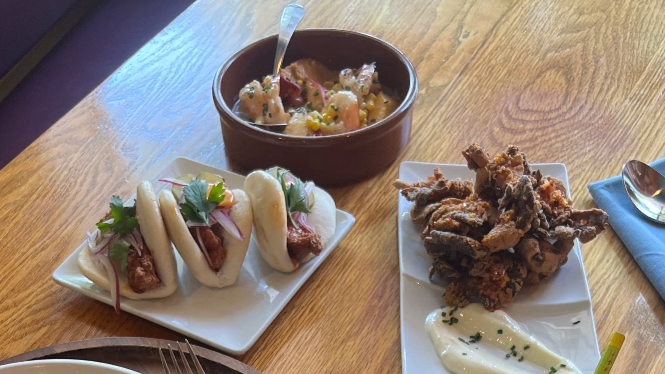 boa bun, grilled prawn, oyster mushroom small plates on wooden table