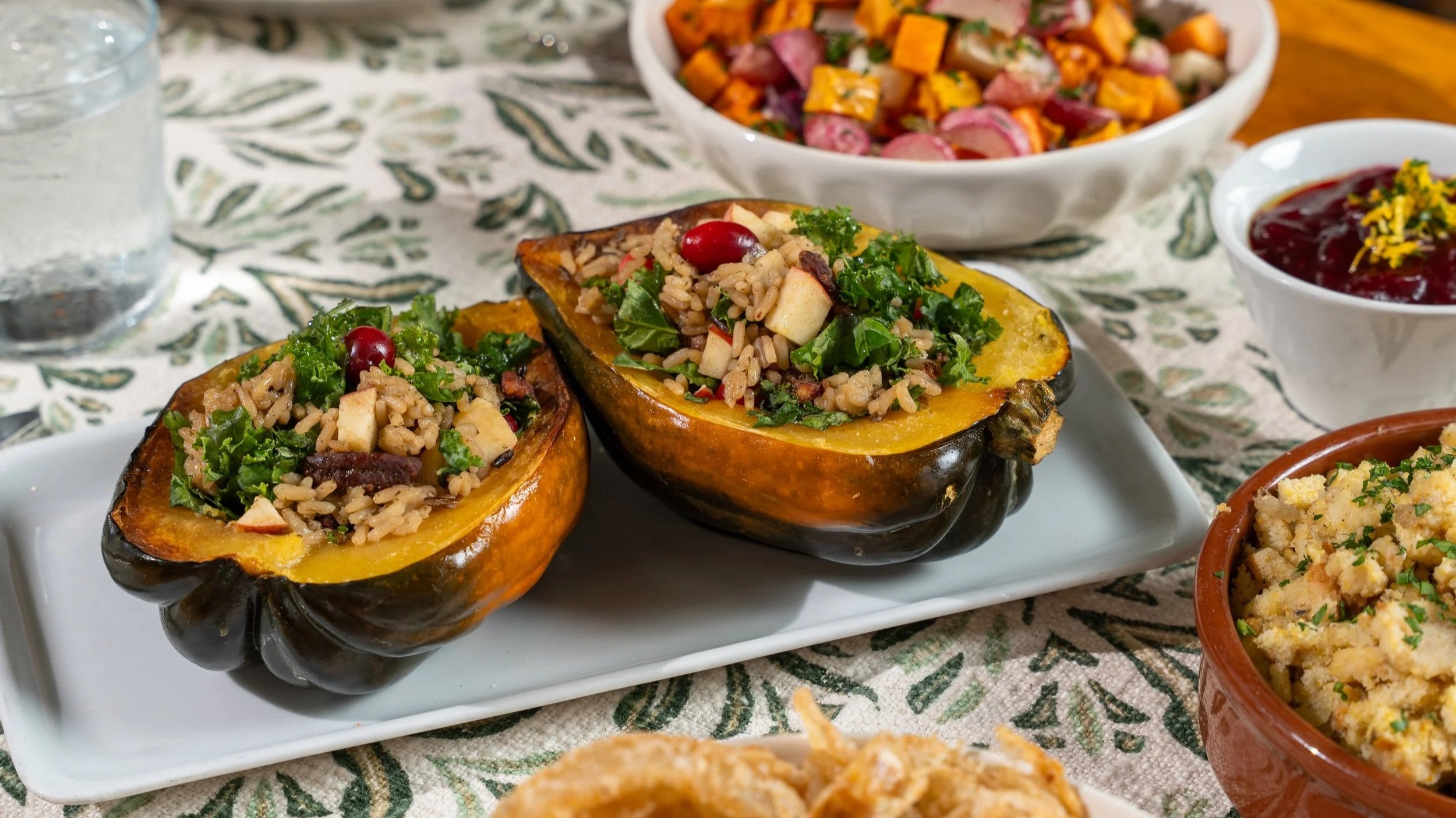 Vegan stuffed acorn squash, fresh cranberries, kale, rice, apples, herbs.