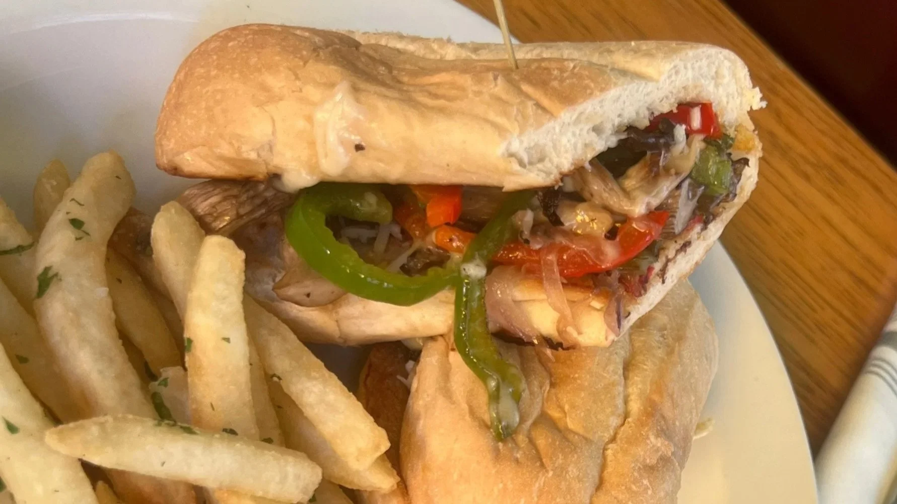 Philly Cheese Sandwich: shredded beef or oyster mushroom (shown here), grilled bell pepper and white onion, cheese sauce, provolone (gluten free option, vegan option)
