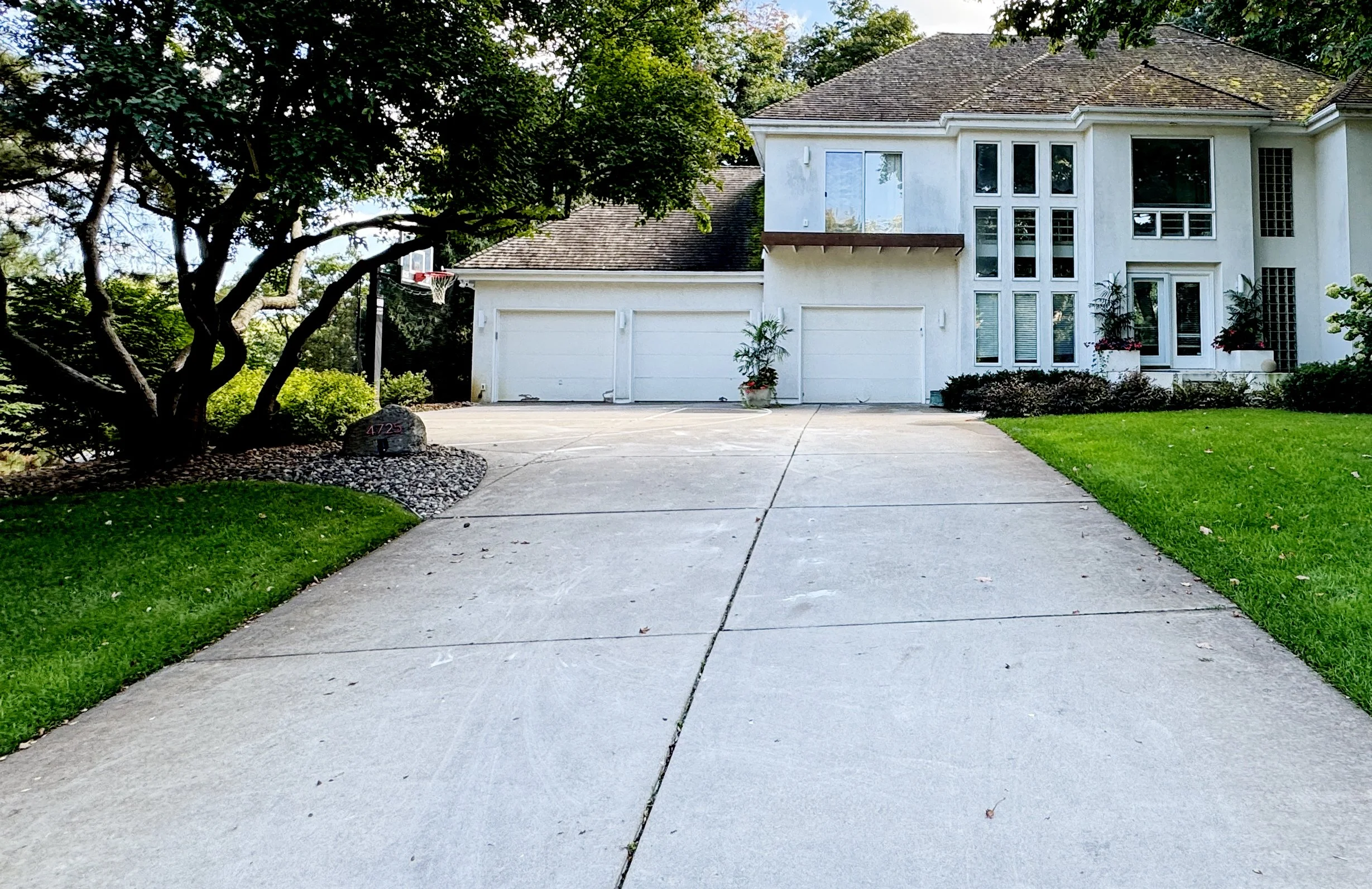Photo of a concrete driveway taken from the srteet looking towards the house.