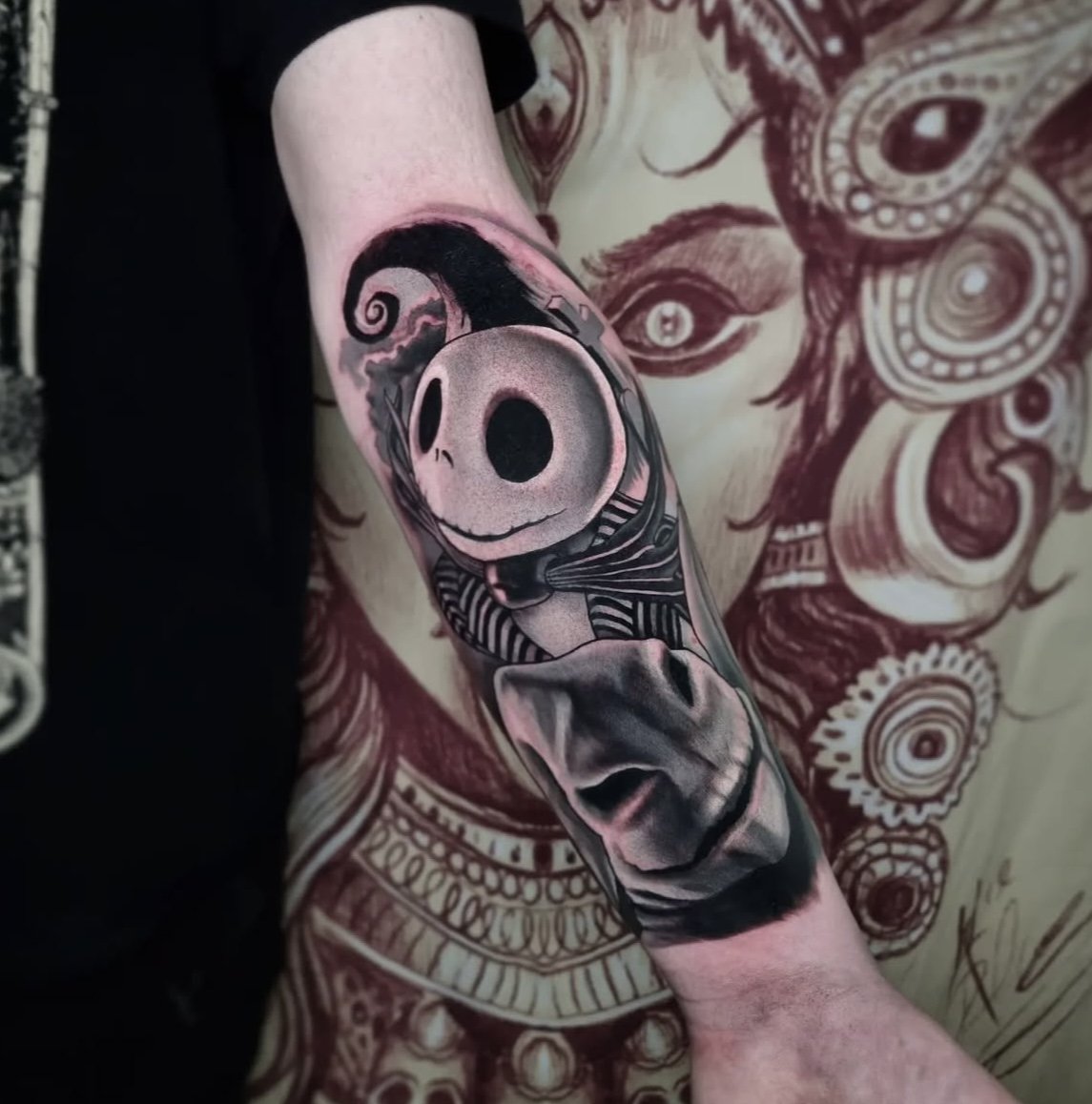 Tattoo featuring a character with a skull-like head and striped suit on a person's arm, set against a detailed background with intricate designs.