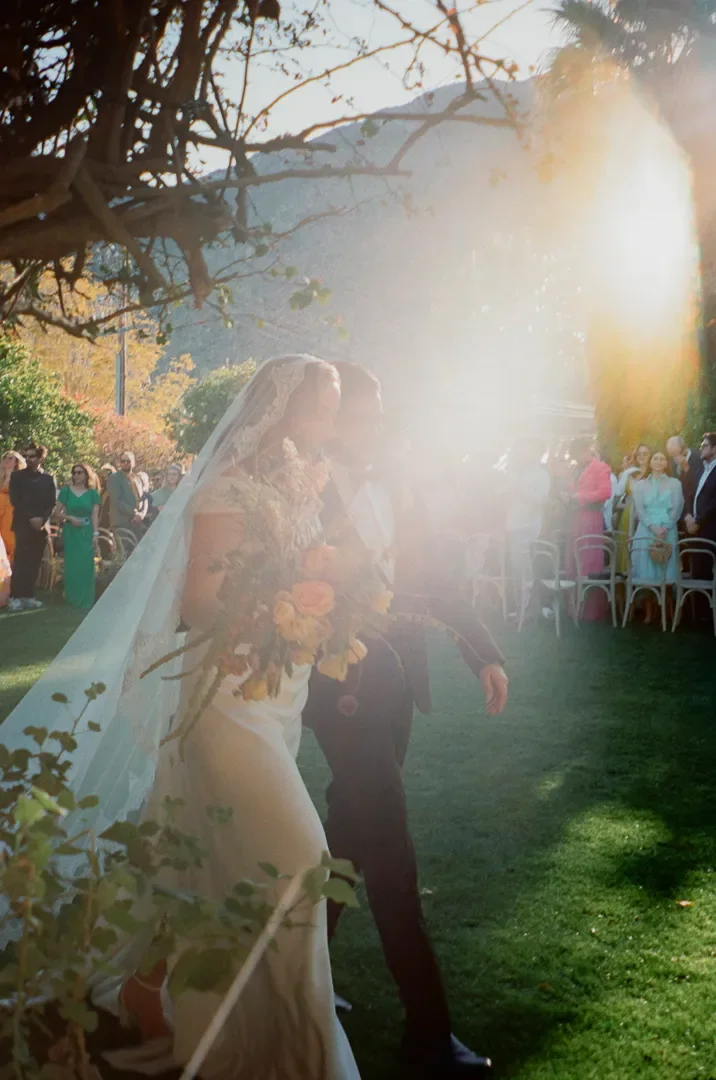 Bride and groom walking down the aisle at Casa Cody in Palm Springs during golden hour, photographed on 35mm film wedding photography.