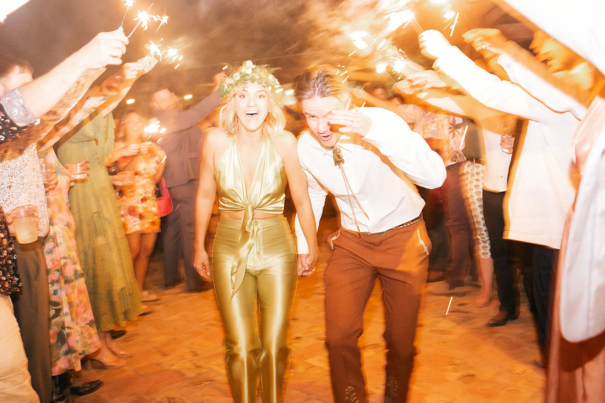 Bride and groom running through a sparkler exit at a Palm Springs wedding, photographed on 35mm analog film with flash (10-hour full day coverage).