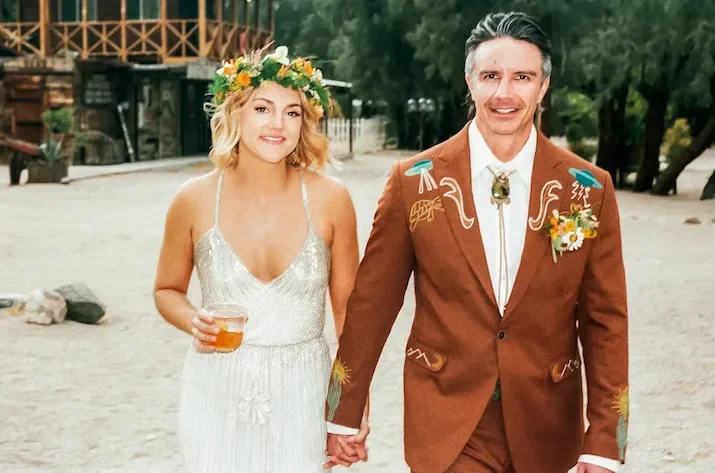 Bride and groom walking hand-in-hand at The Lazy C Ranch in Palm Springs during a space cowboy themed wedding, photographed on 35mm film.