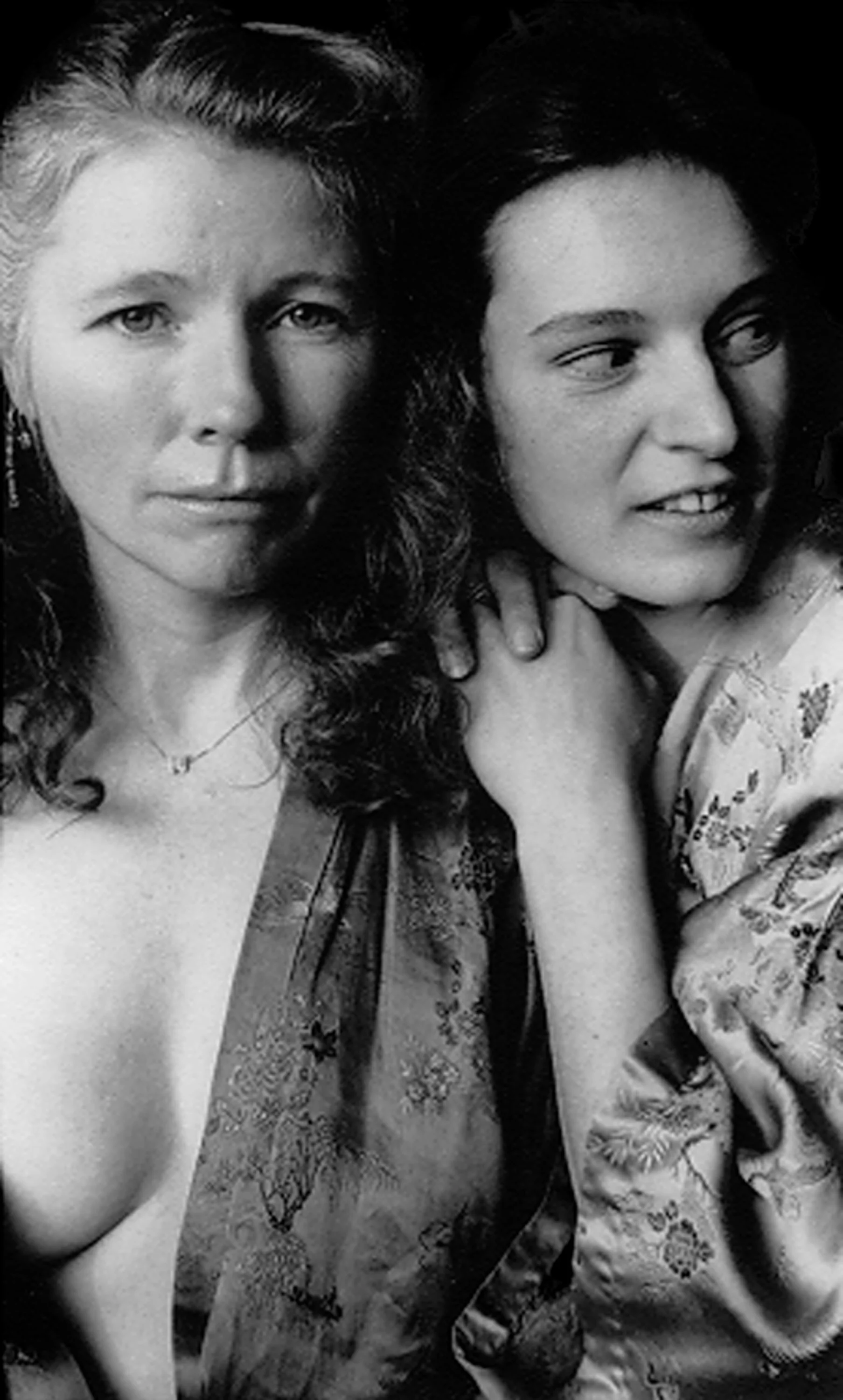 Black and white photo of two women, one older with light hair and one younger with dark hair, both smiling and close together.