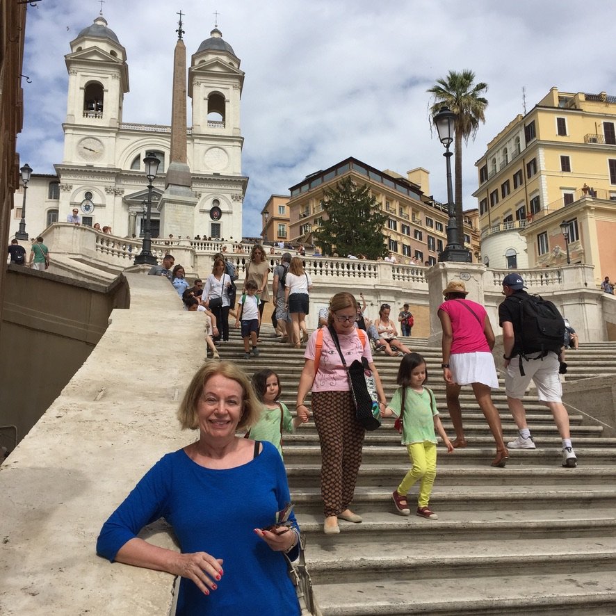 People walking on the Spanish Steps in Rome, with the Trinità dei Monti church in the background.