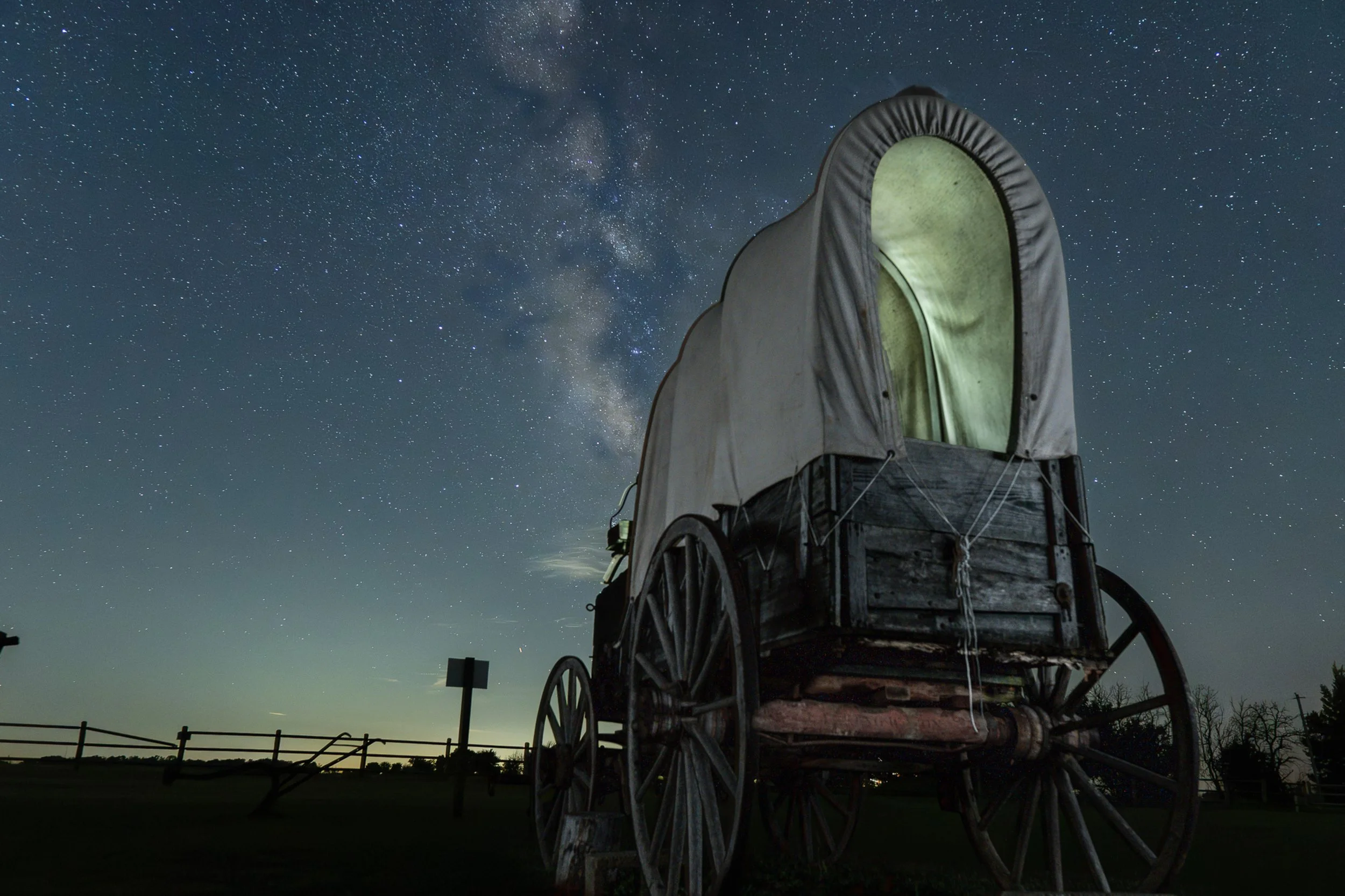 Pioneers under the stars. An old prairie schooner resting under the Milky Way.